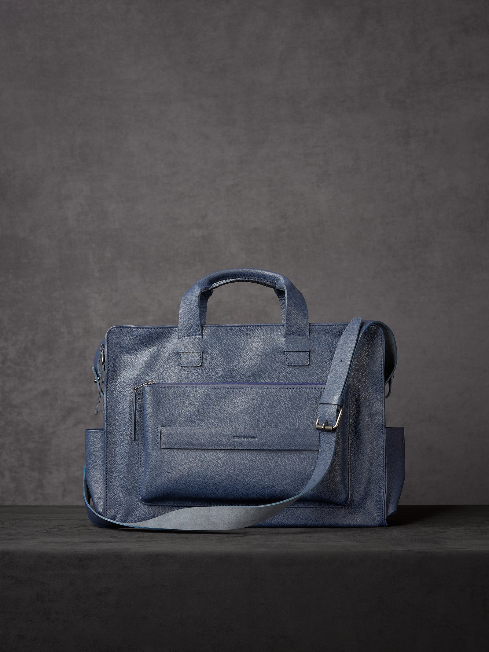 Navy blue full-grain leather briefcase with shoulder strap and handles by Capra Leather.