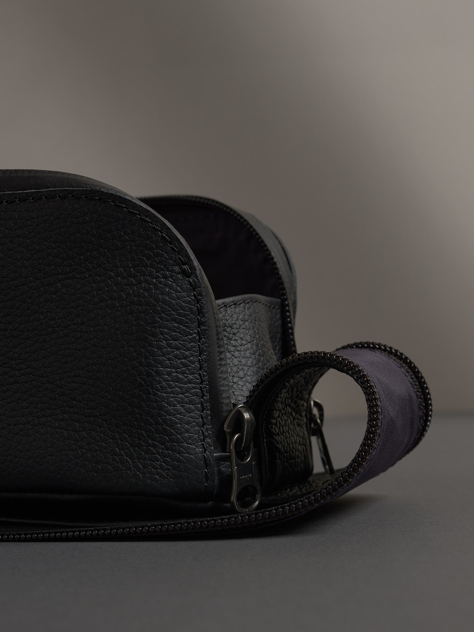 Detail of the pebbled black leather and sturdy metal zipper on the Capra Toiletry Bag.