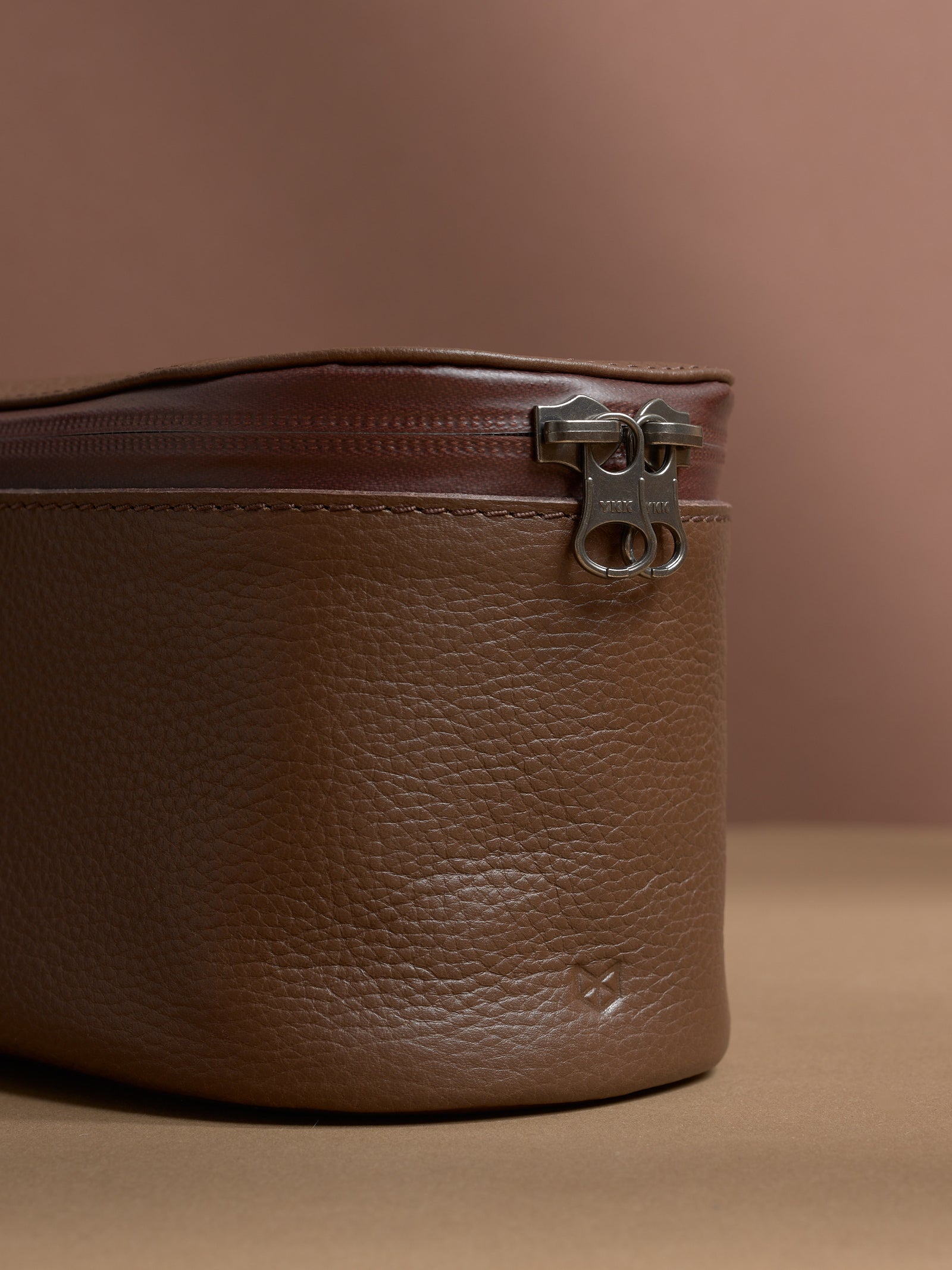 Close-up of the YKK zipper and the rich pebbled texture of the brown Capra Leather.