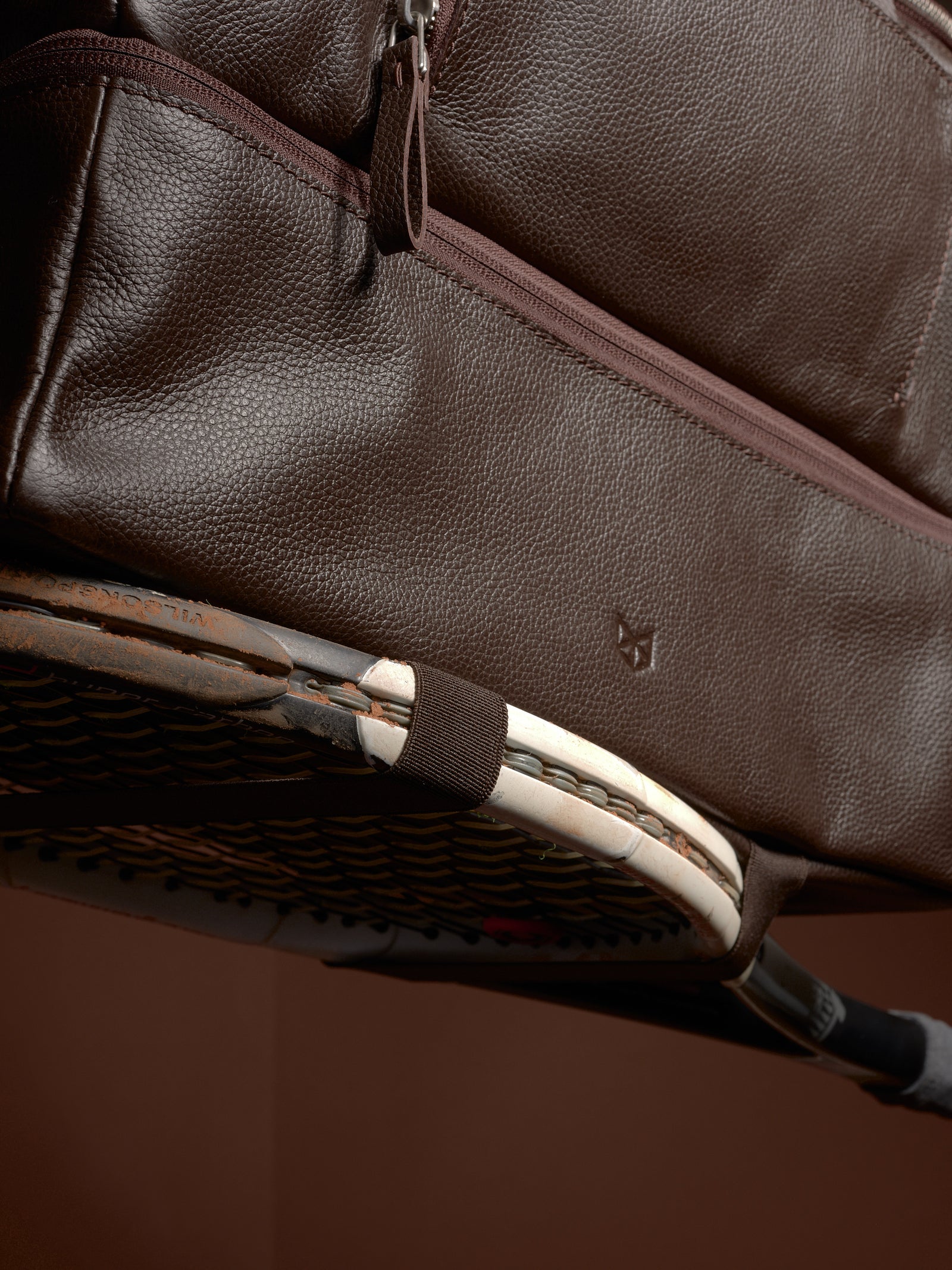 Close-up of the Ventra Holdall bag's side straps holding a tennis racket.