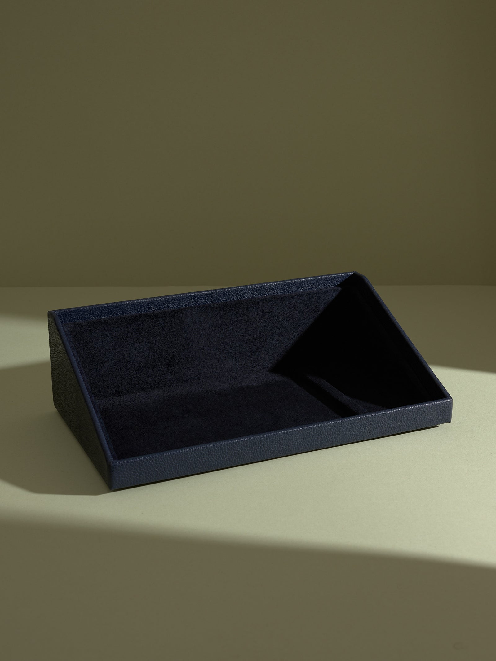 The Podium navy leather accessory drawer from the watch box stand, lined with suede.