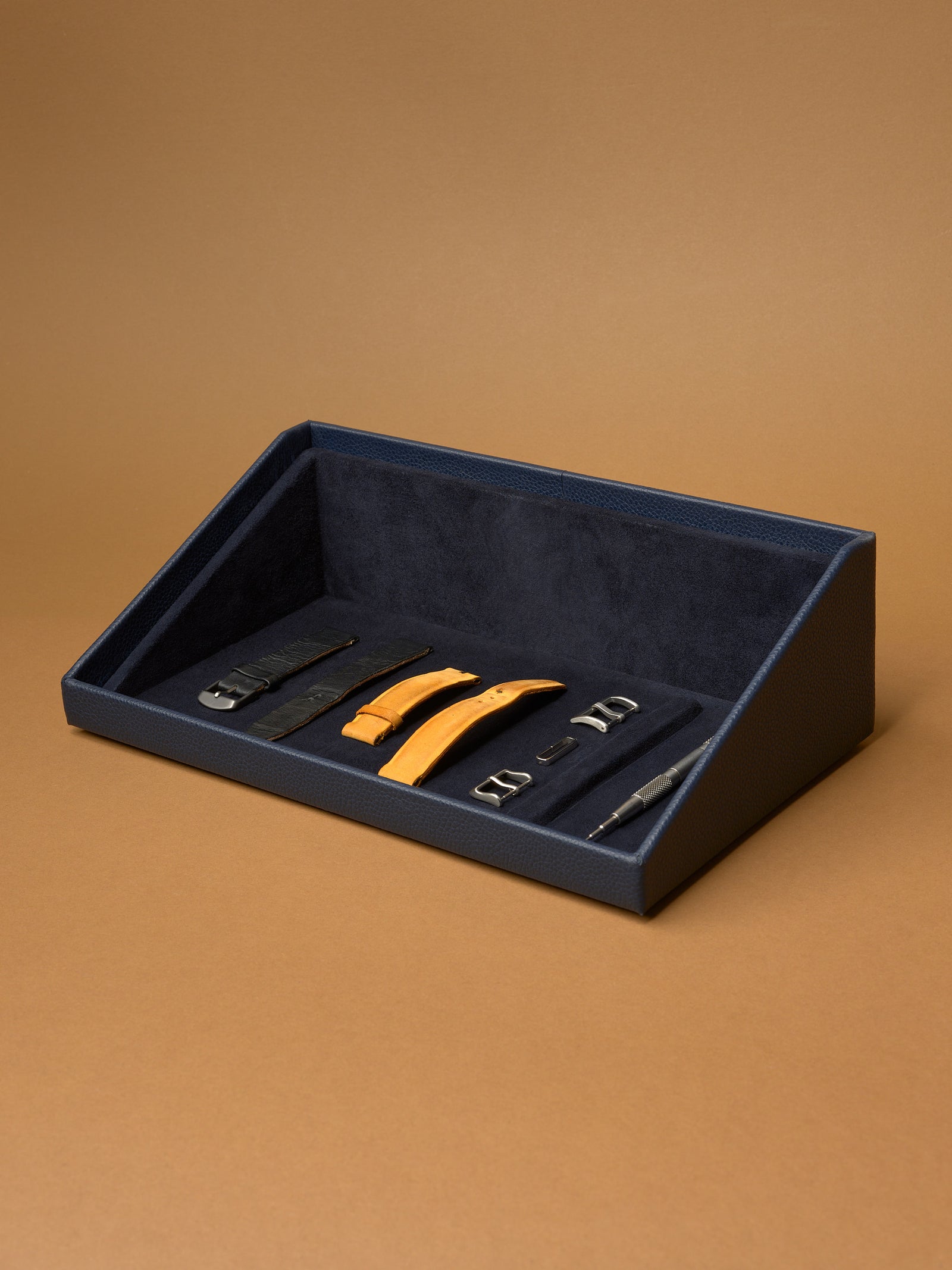 The Podium Detail of watch straps, buckles, and a spring bar tool in the Capra leather accessory storage drawer.