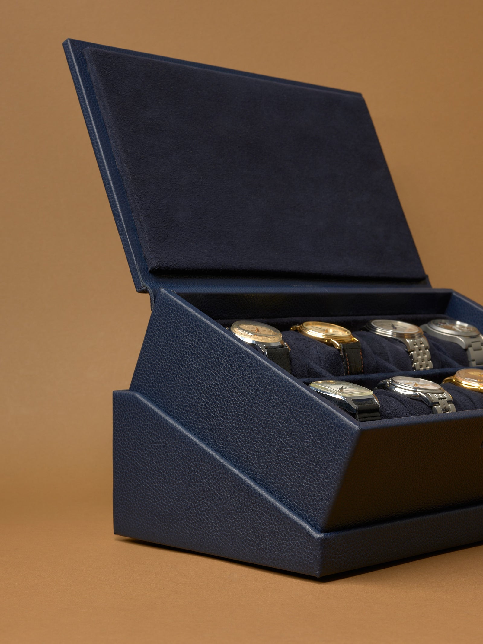 The Podium Side view of the open, slanted Capra leather watch display box on its hidden storage drawer base.
