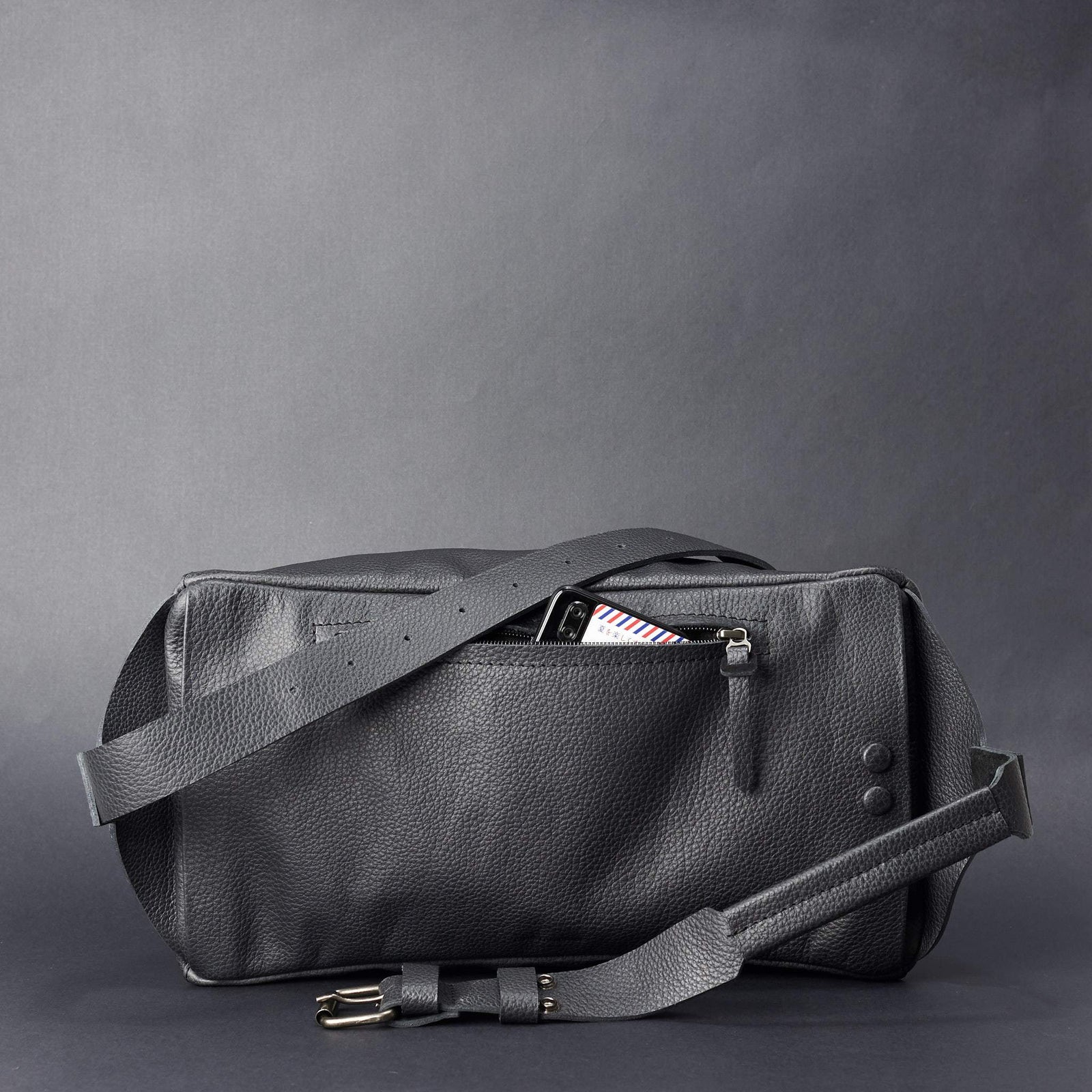 Black Fenek sling bag backpack made by Capra Leather. Styling back pocket. Easy access street bag.