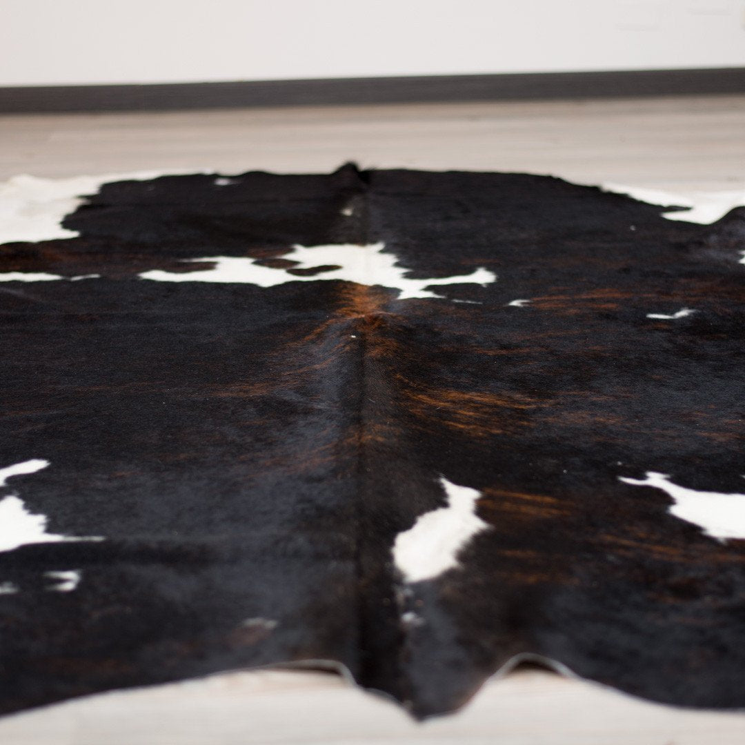 Large Cowhide Rug on the floor. Black and Caramel Large Cowhide Rug, Home Décor Ideas, Large Rugs, White, Cow hide. Home Hair on hide Floor
