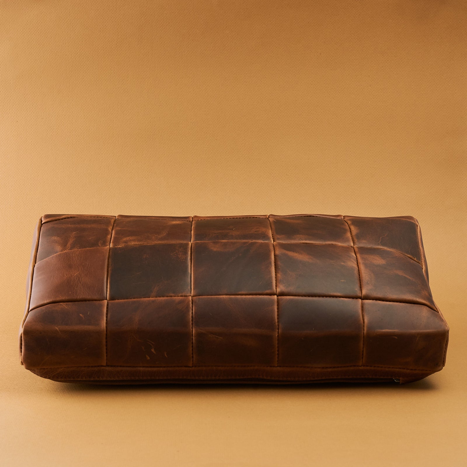 Front. Ergonomic under desk footrest cover in distressed tan by Capra Leather