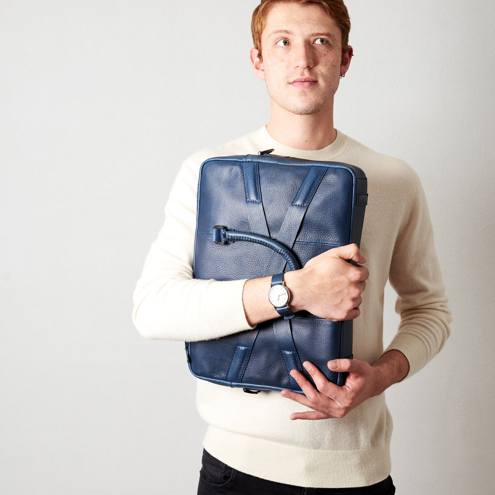 Holding business briefcase. Blue leather briefcase laptop bag for men. Gazeli laptop briefcase by Capra Leather.