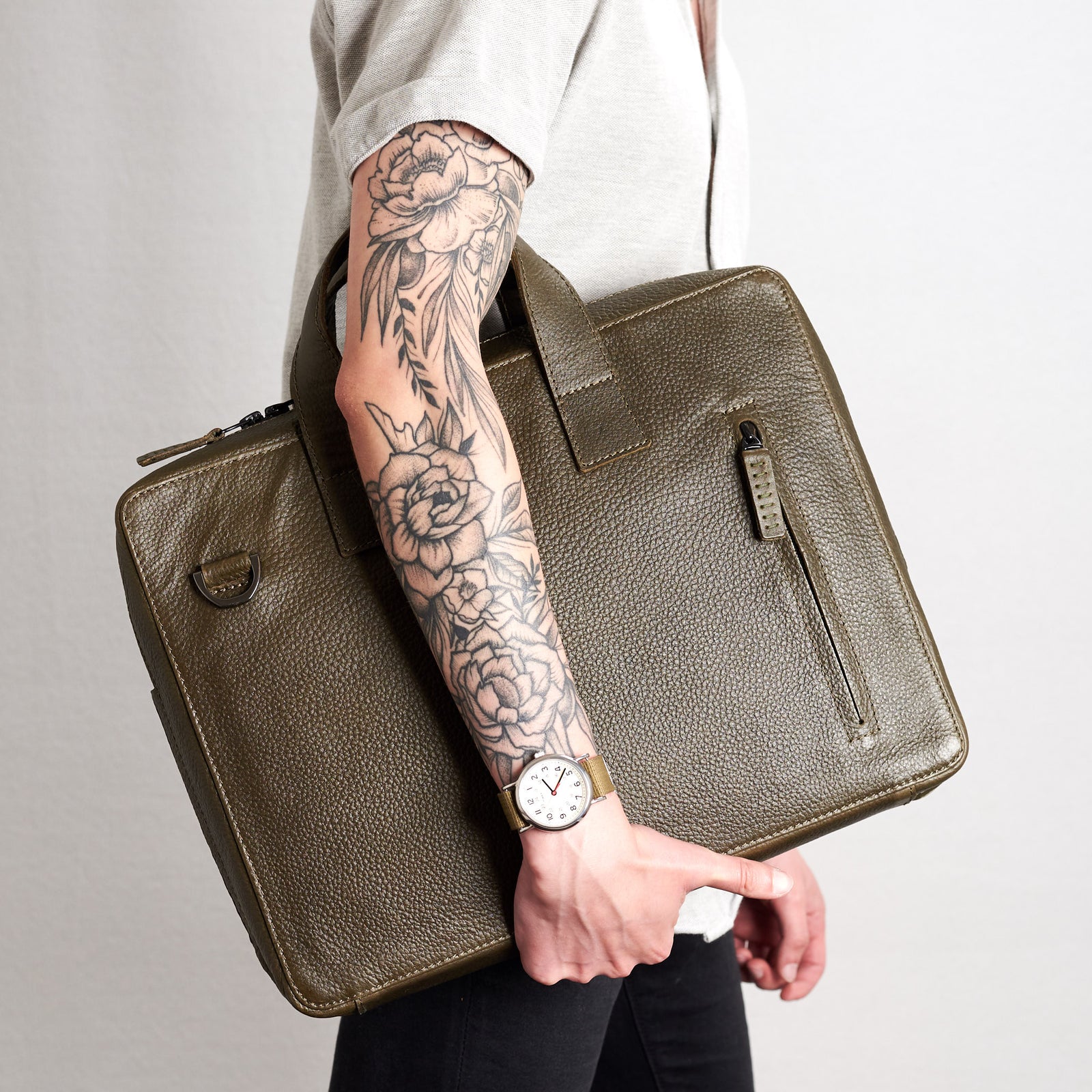 Style holding Roko with hands. Green briefcase by Capra Leather.