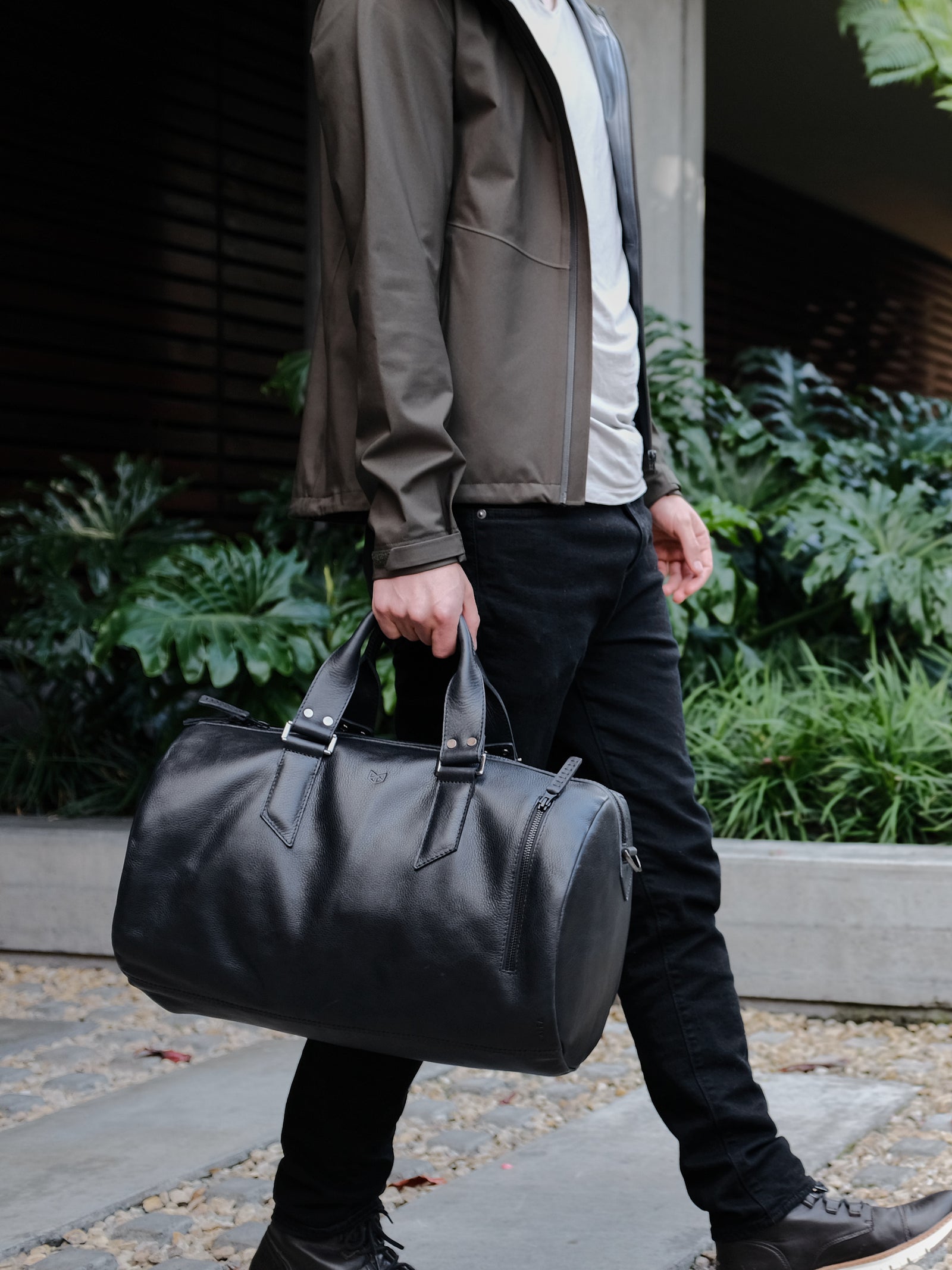 Style outside photo. Black leather duffle handbag for men. Travel designer bag