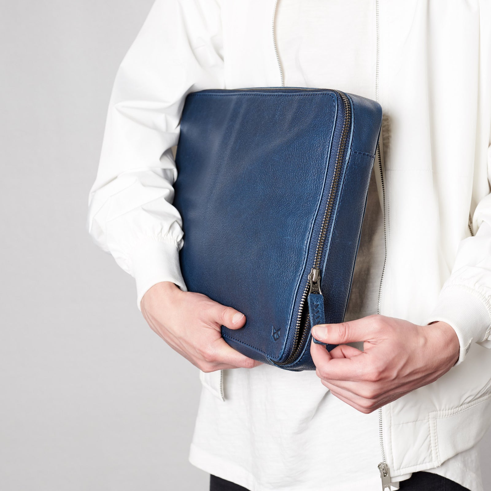 Hand stitched pull tabs. Navy blue travel gadget bag by Capra Leather