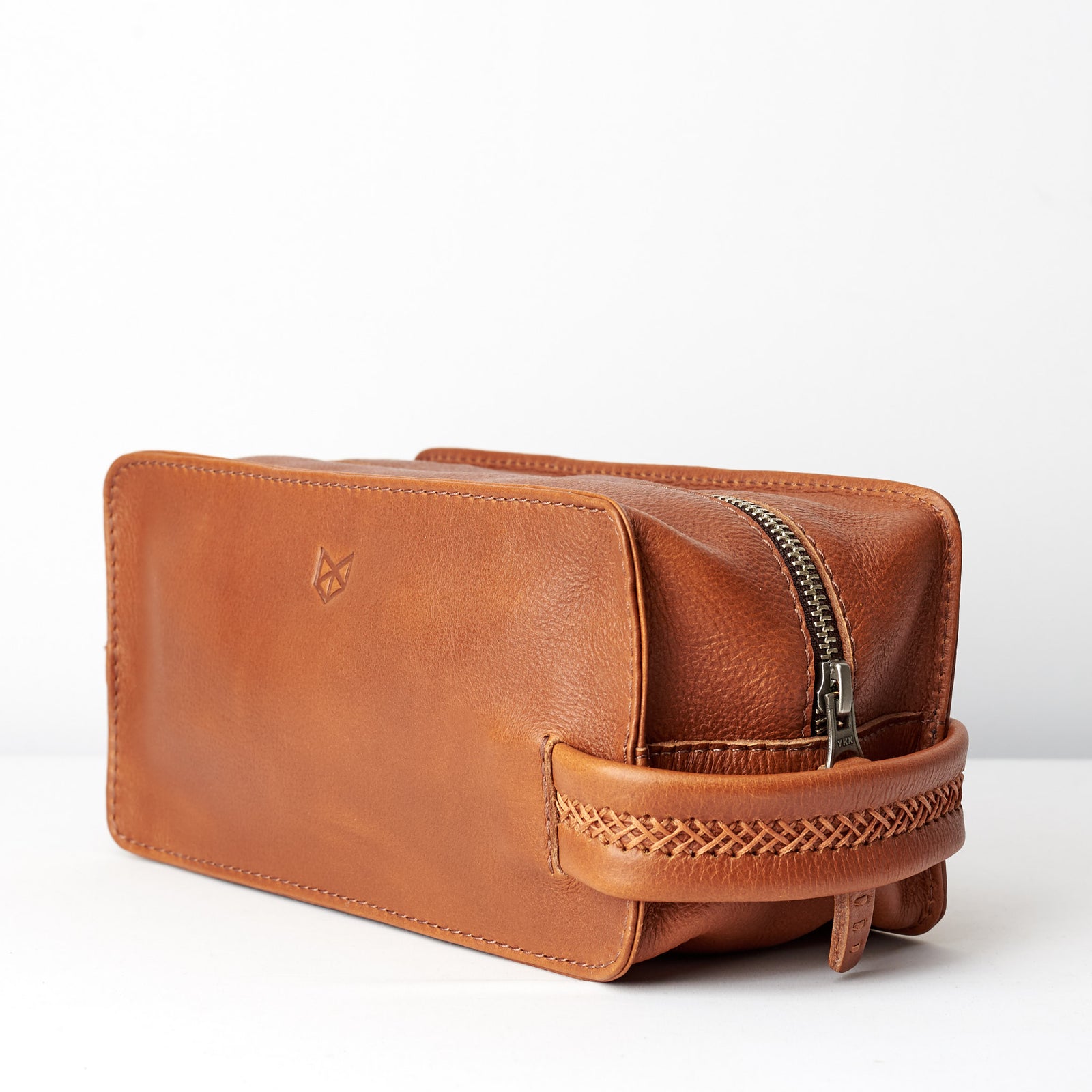 Side view. Tan leather toiletry, shaving bag with hand stitched handle. Groomsmen gifts. Leather good crafted by Capra Leather