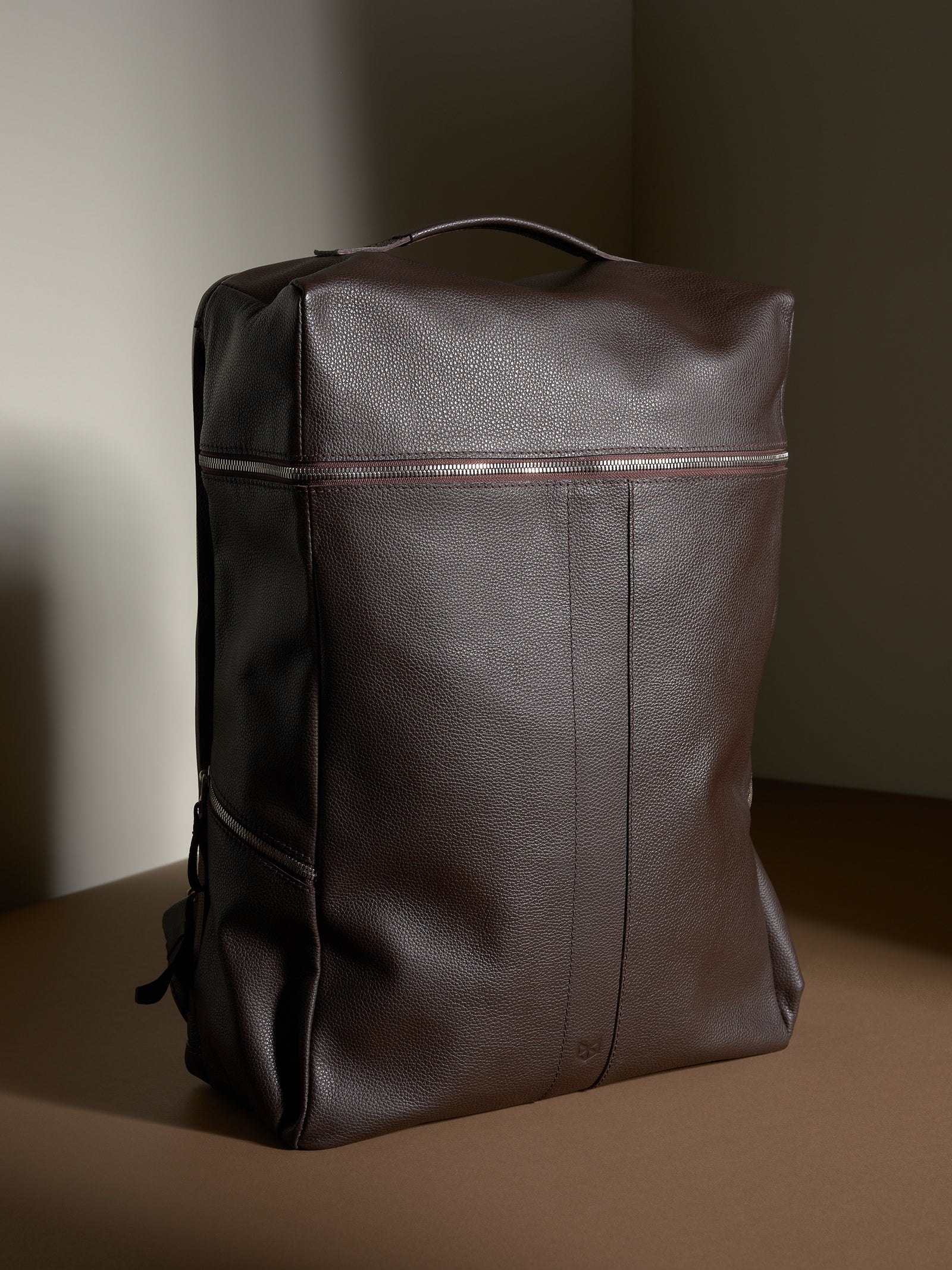 Capra Leather Banteng dark brown full-grain leather backpack with silver zipper closure.