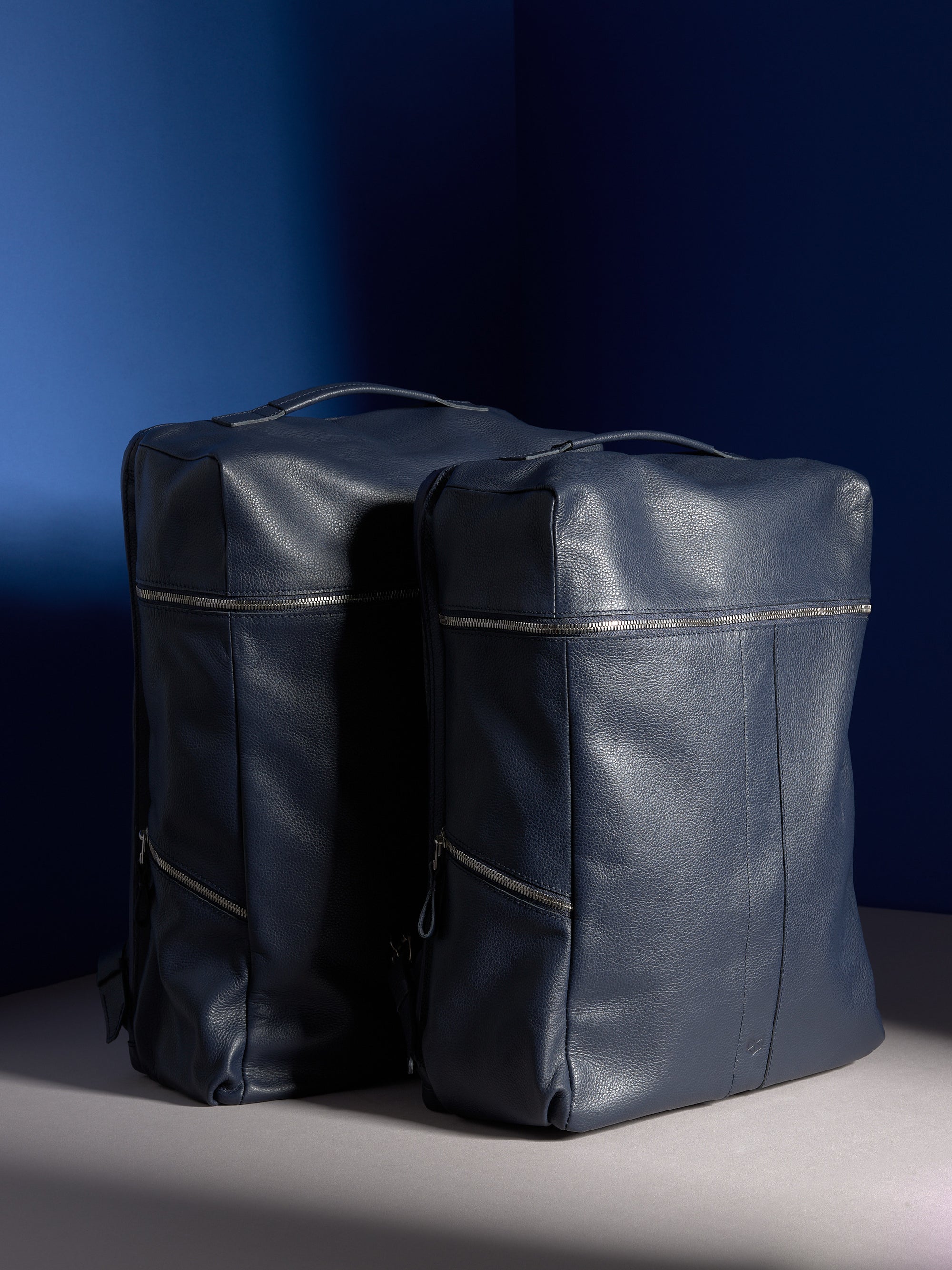 A close-up of the Banteng backpack's top handle, showcasing the rich texture of the navy pebbled leather and stitching.