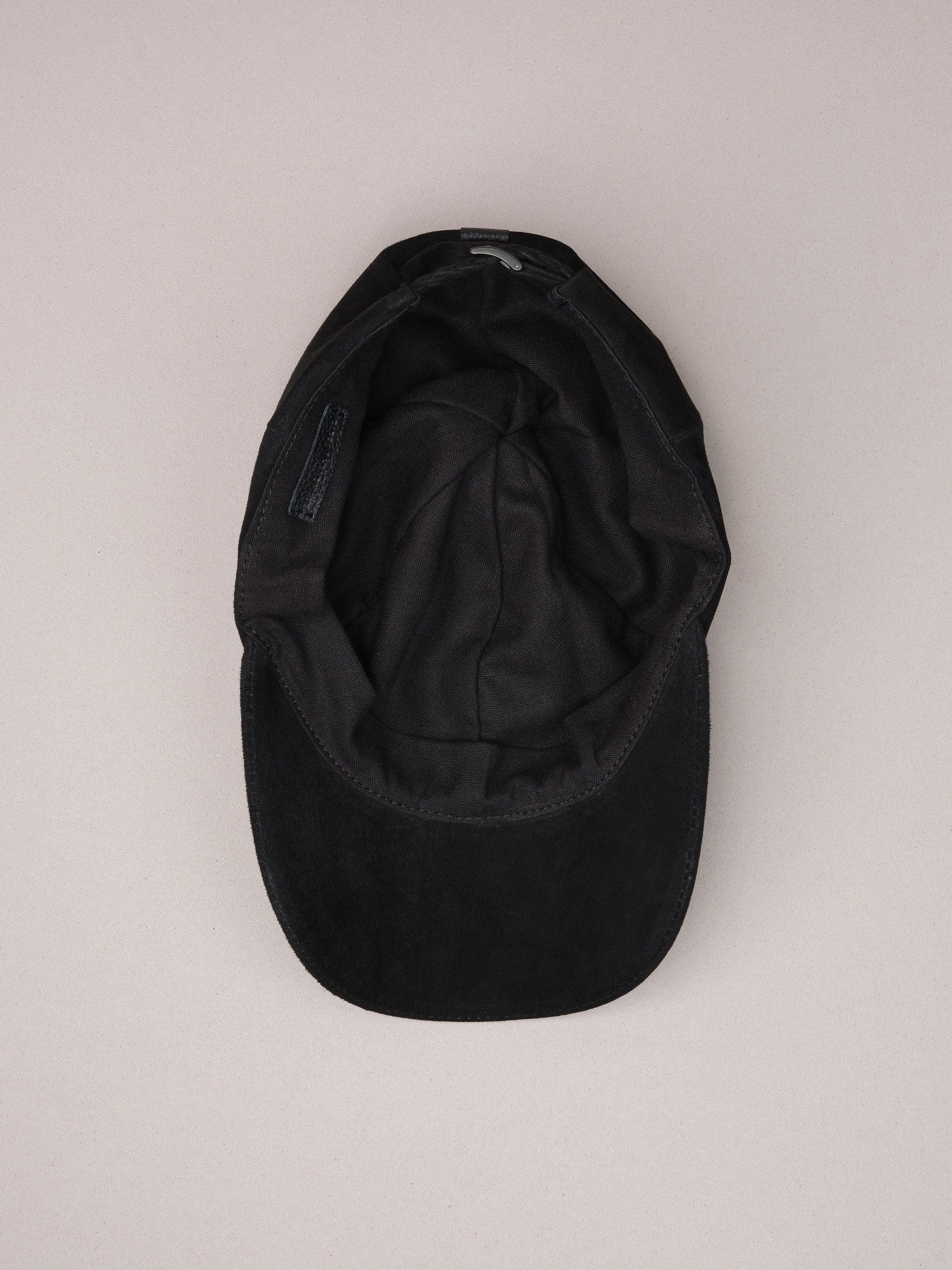 Soft natural linen lining inside the black suede baseball cap.