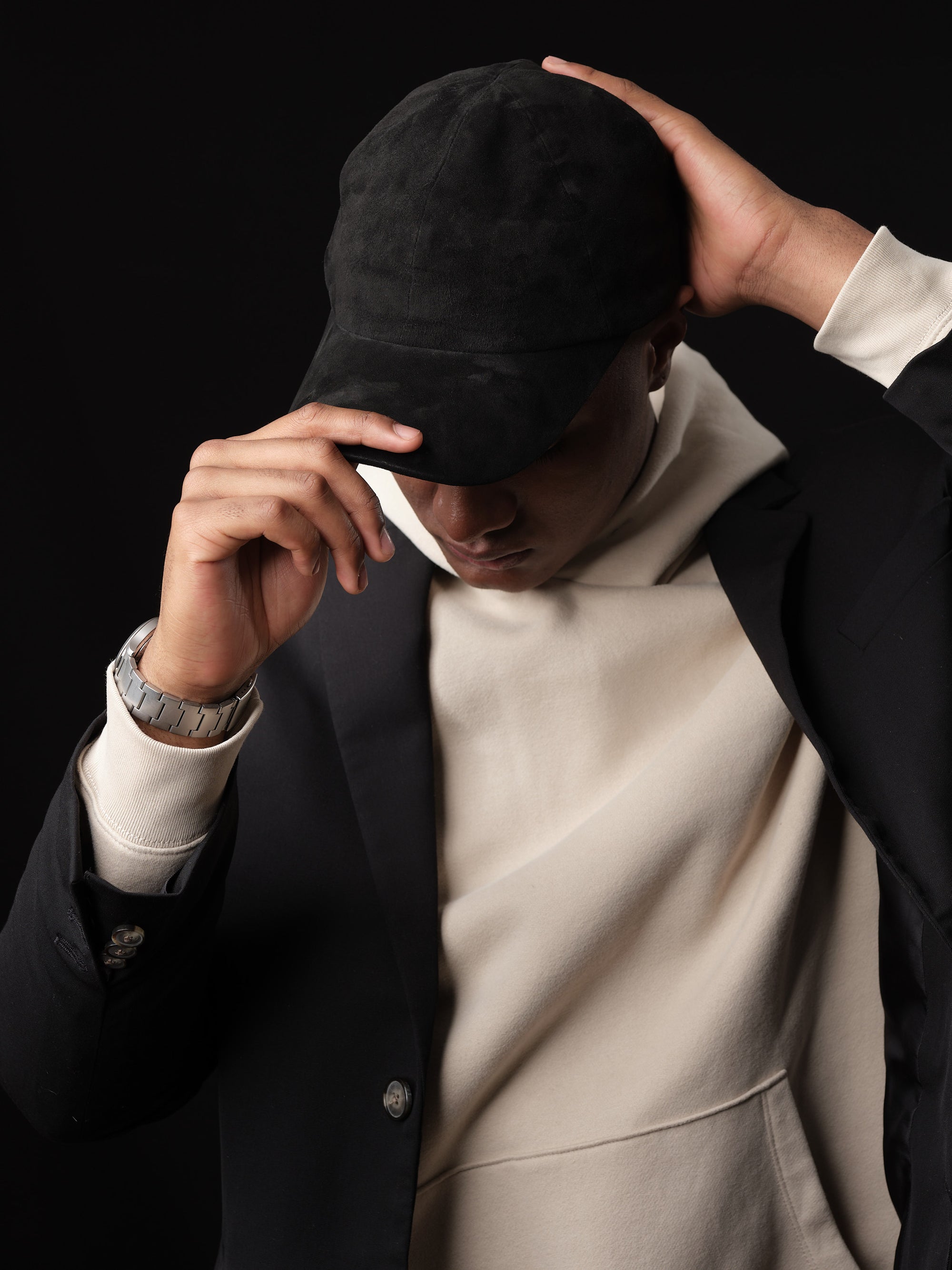 Man wearing a black suede baseball cap.