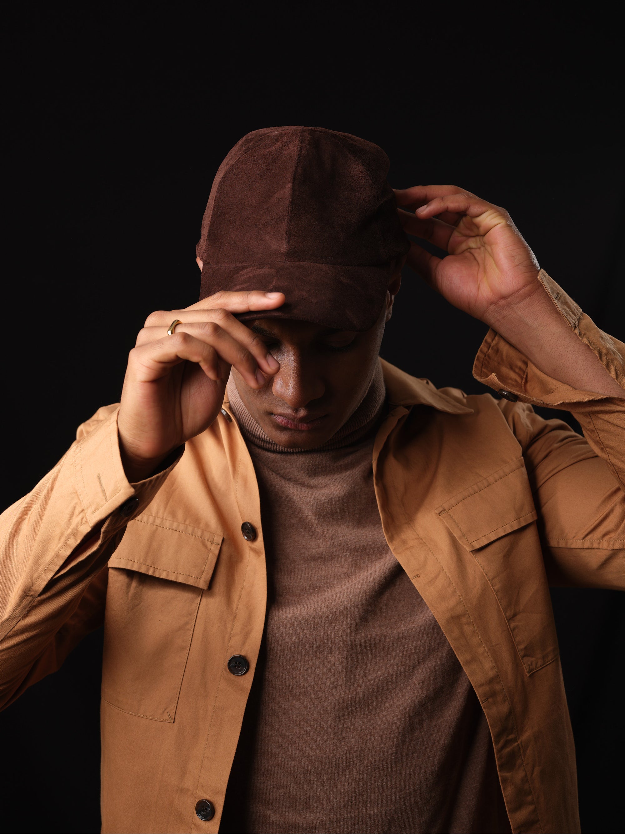 Detail of the braided strap and buckle on a brown suede baseball cap