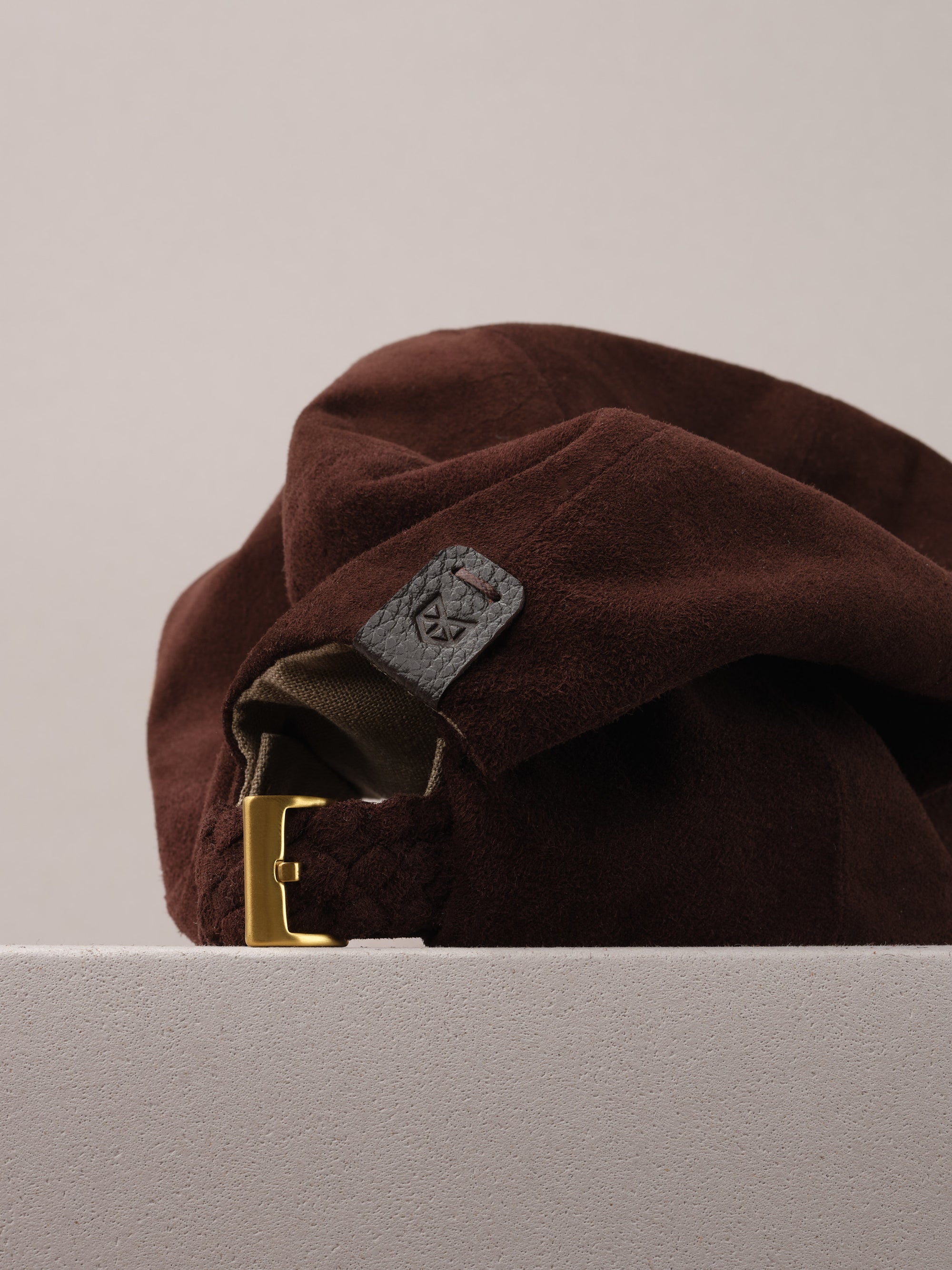 Capra Leather logo on the brown suede baseball cap.