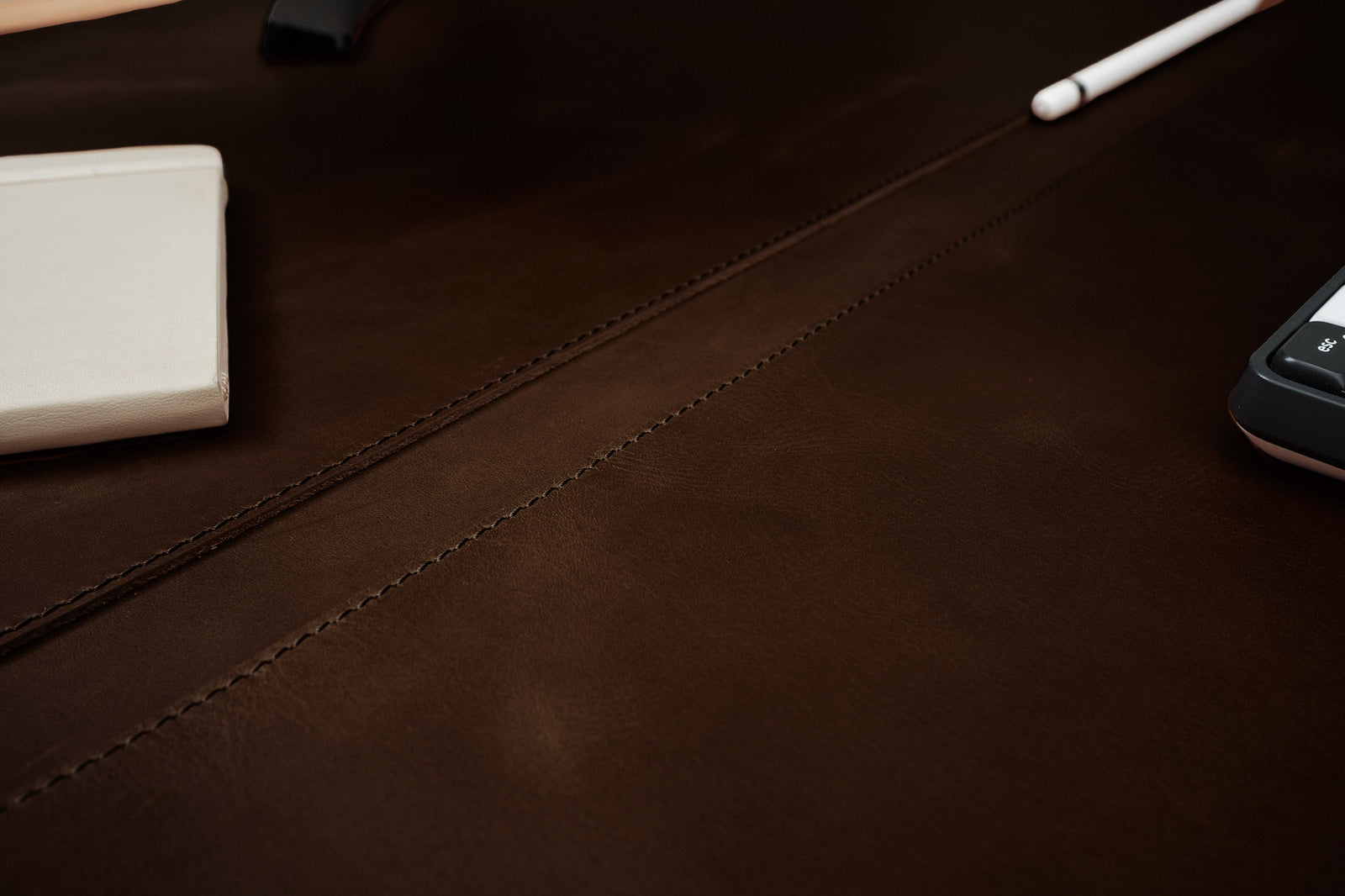 Leather desk pad with an optional pen slot for organization.