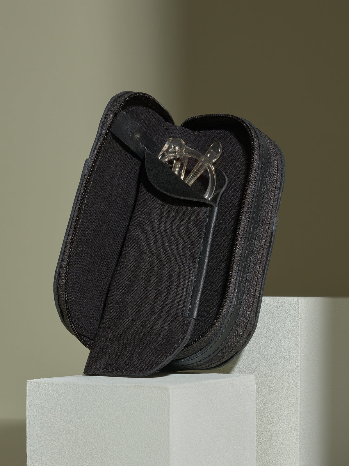Black leather double-glasses case open, revealing the removable soft pouch insert with clear reading glasses.