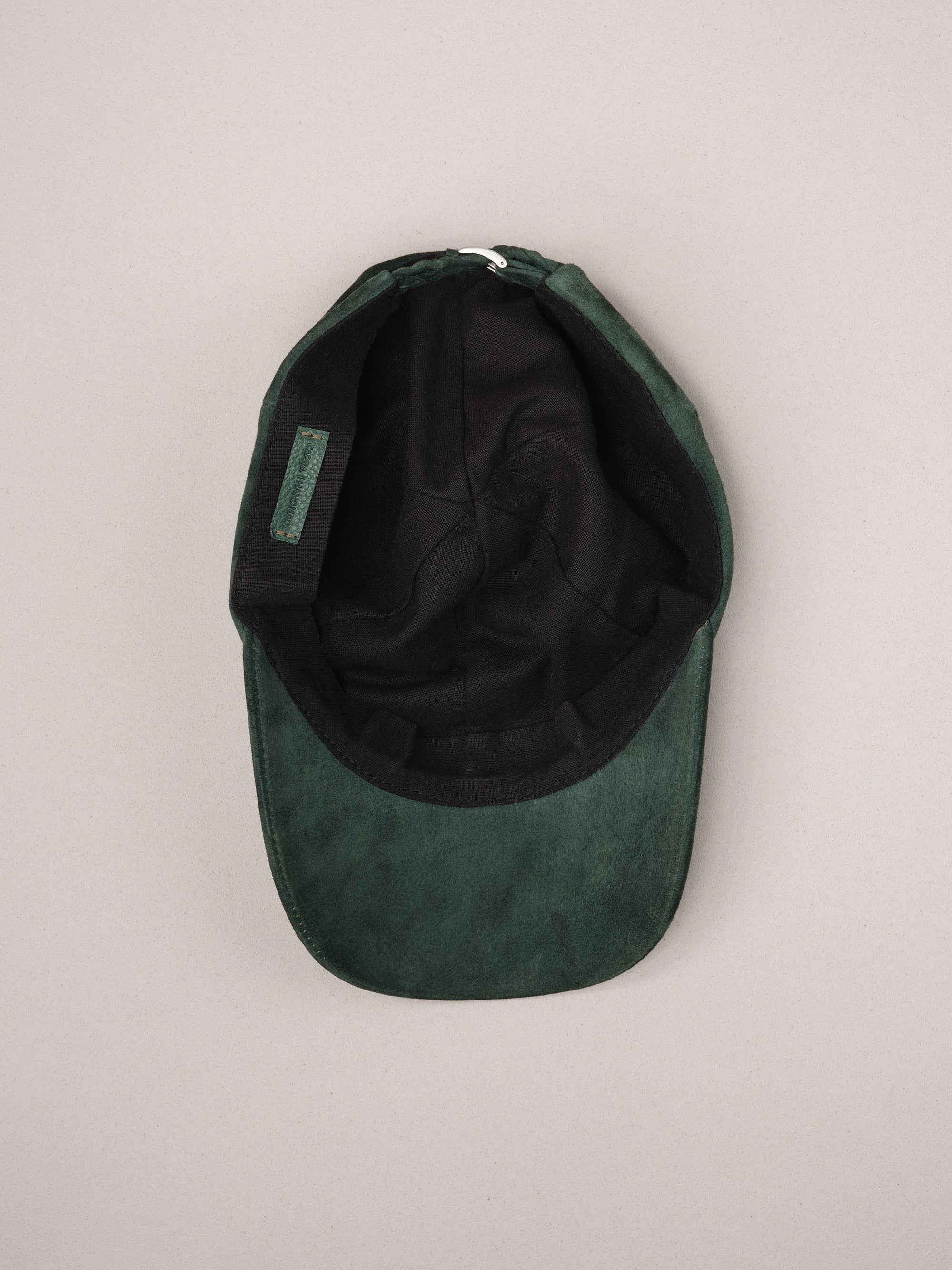 Soft natural linen lining inside the green suede baseball cap.