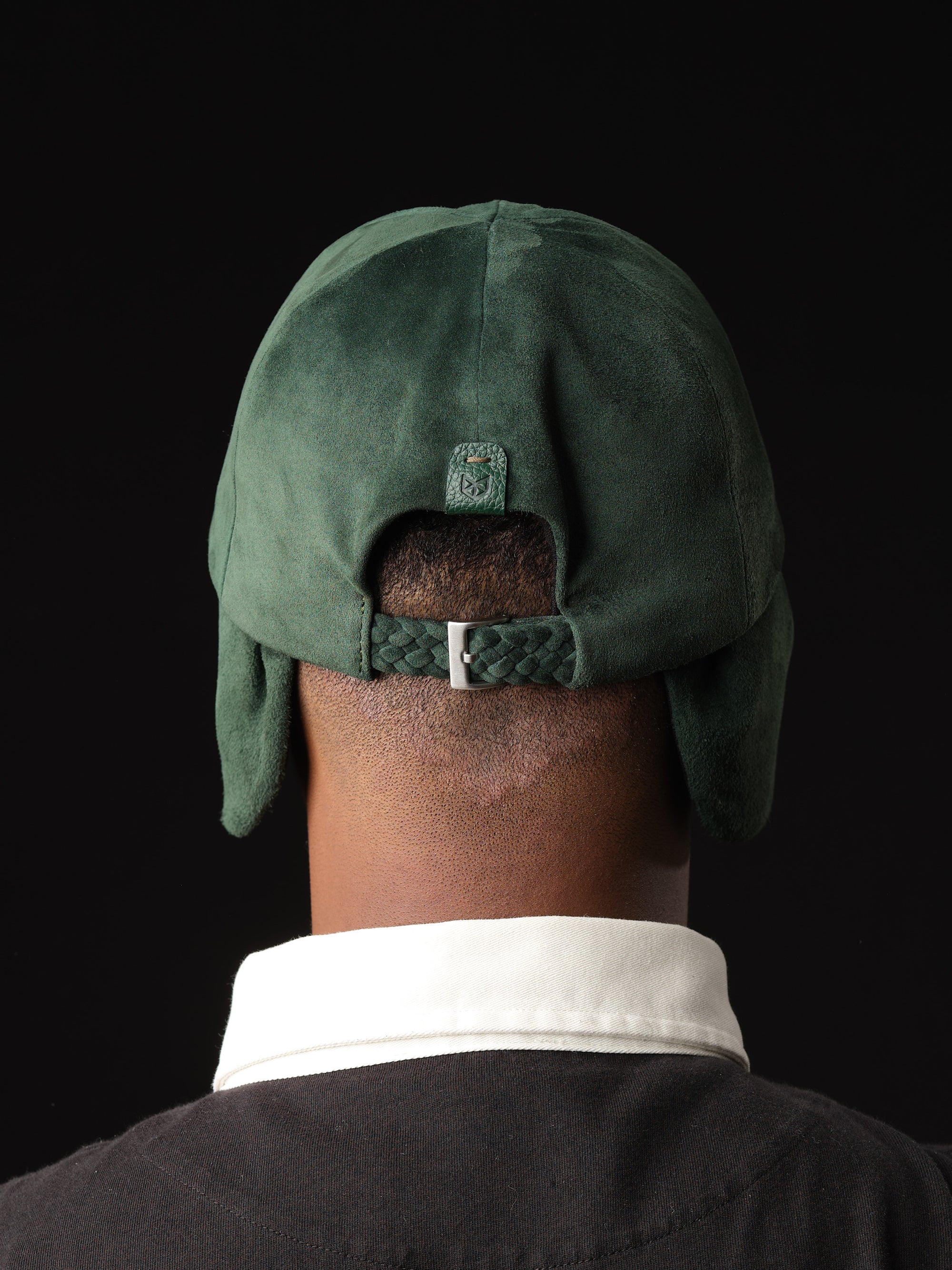 Back view of a green suede baseball cap with braided strap and buckle by Capra Leather