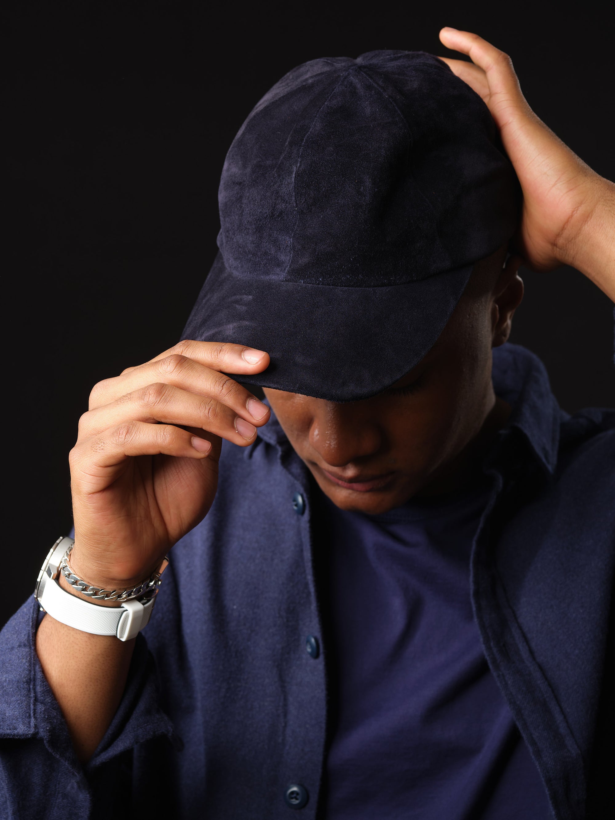 Man wearing a navy suede baseball cap.