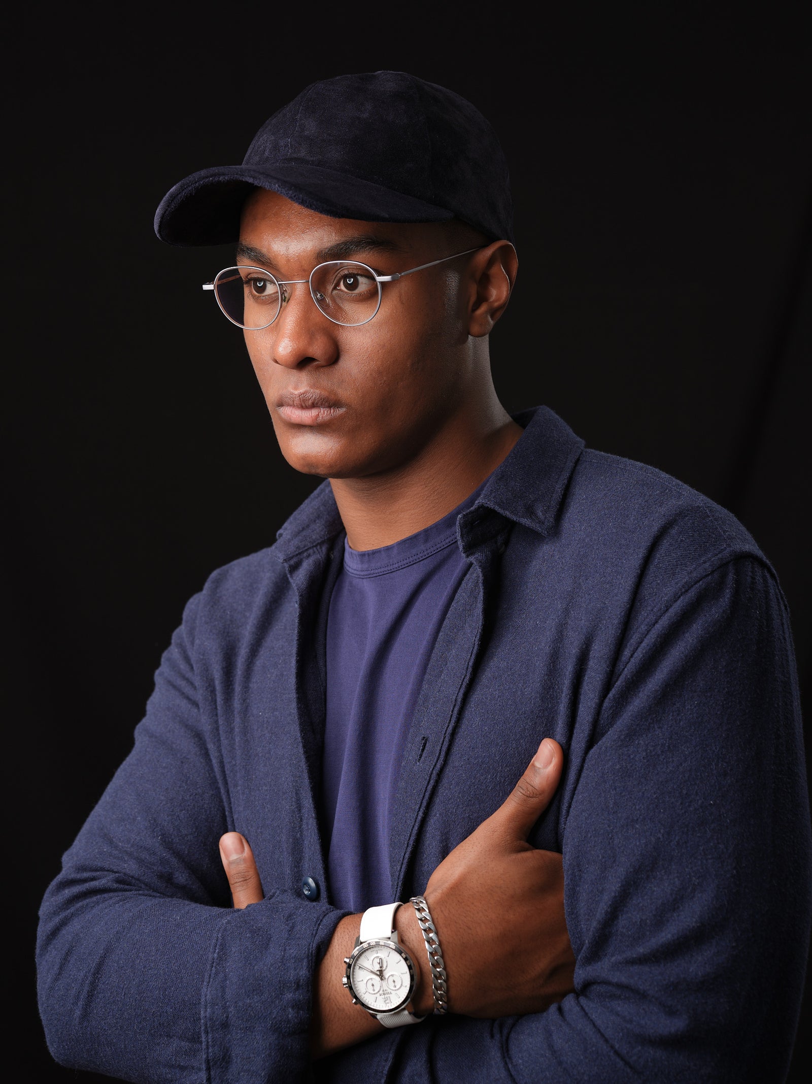 Man wearing a navy suede baseball cap, handcrafted by Capra Leather