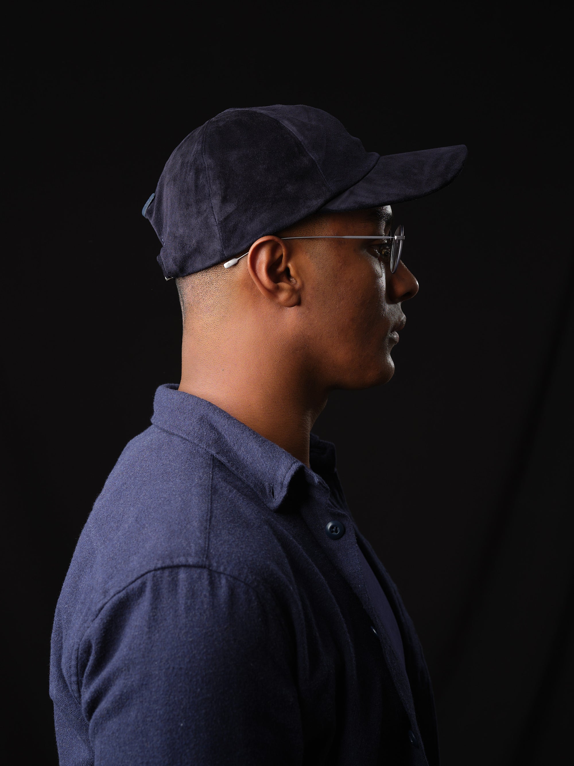 Studio shot of a man in a classic navy suede baseball cap with ear flaps