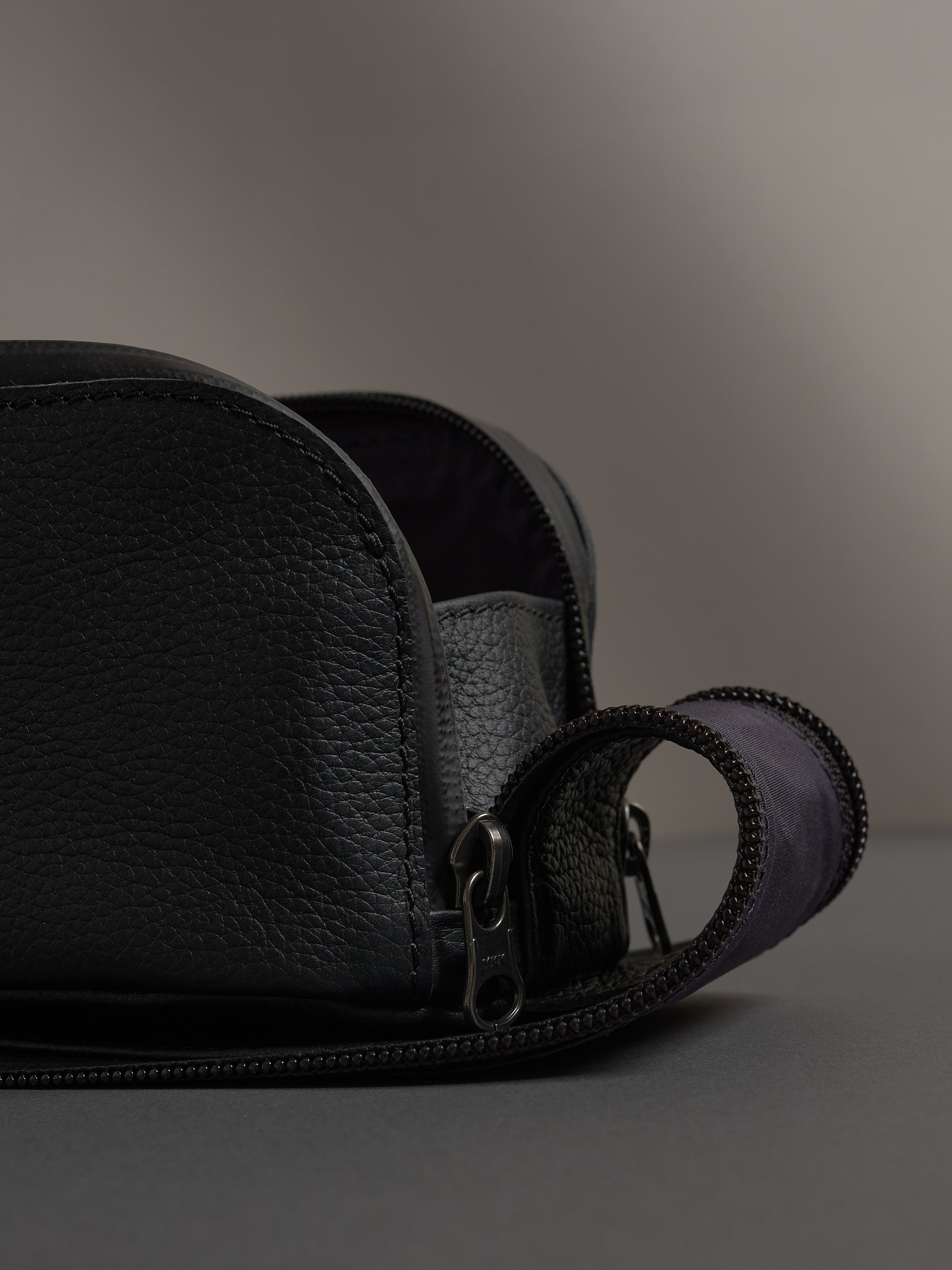 Detail of the pebbled black leather and sturdy metal zipper on the Capra Toiletry Bag.