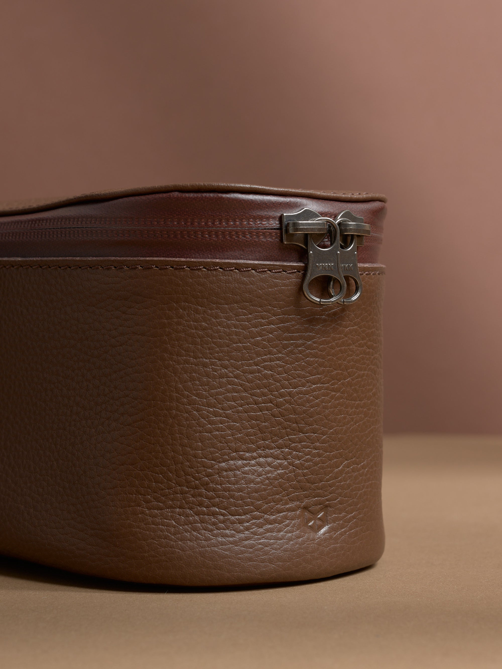 Close-up of the YKK zipper and the rich pebbled texture of the brown Capra Leather.