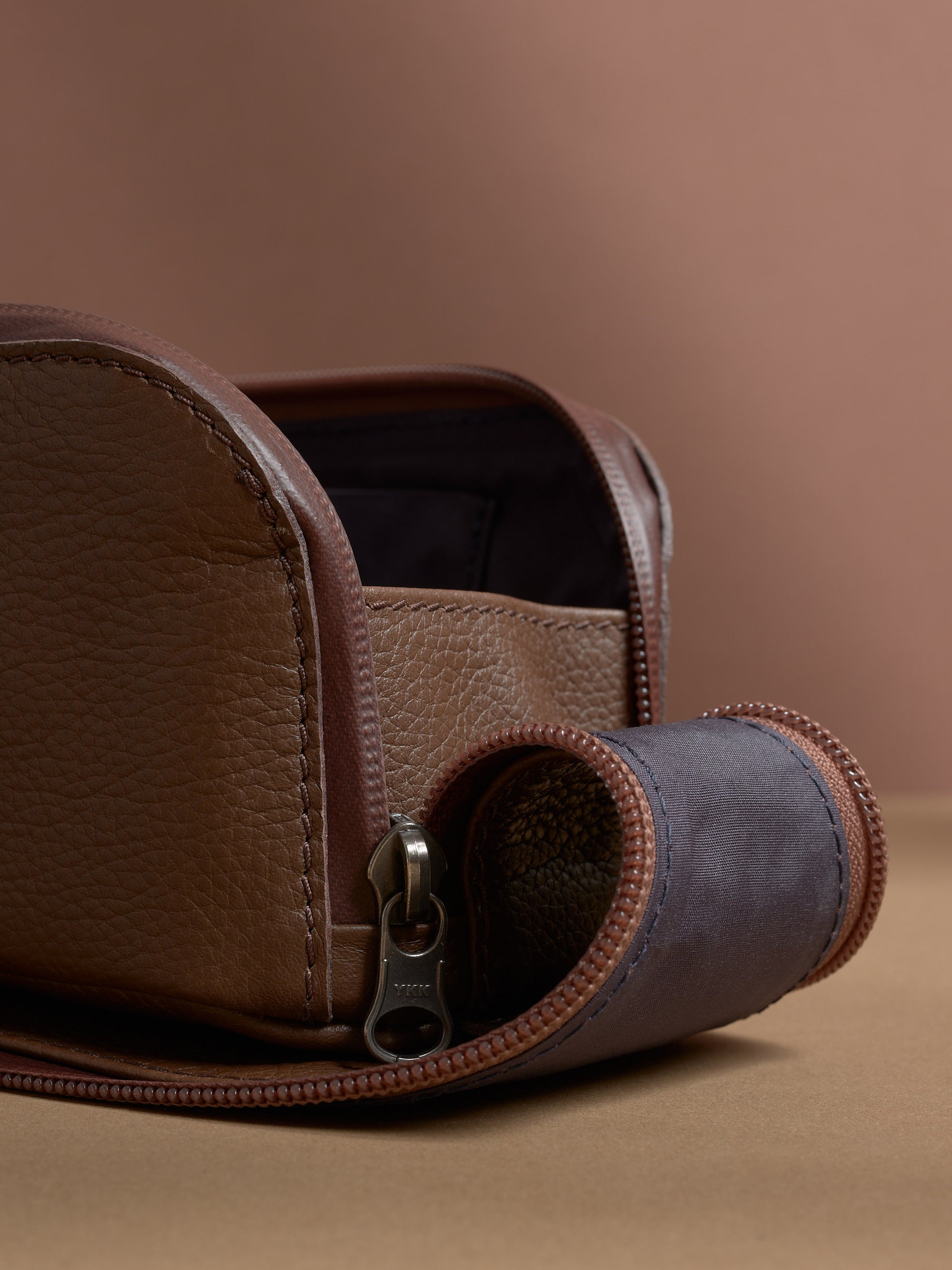 Close-up of the pebbled brown Capra Leather texture and durable YKK zipper detail