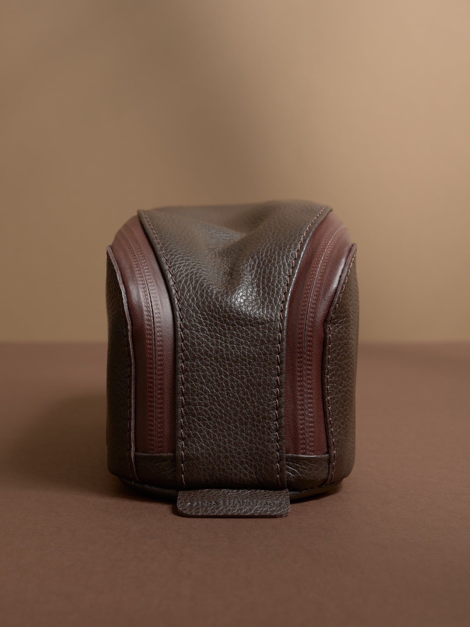 Front view of the dark brown Capra Leather Toiletry Bag, highlighting the leather texture and zipper lines.