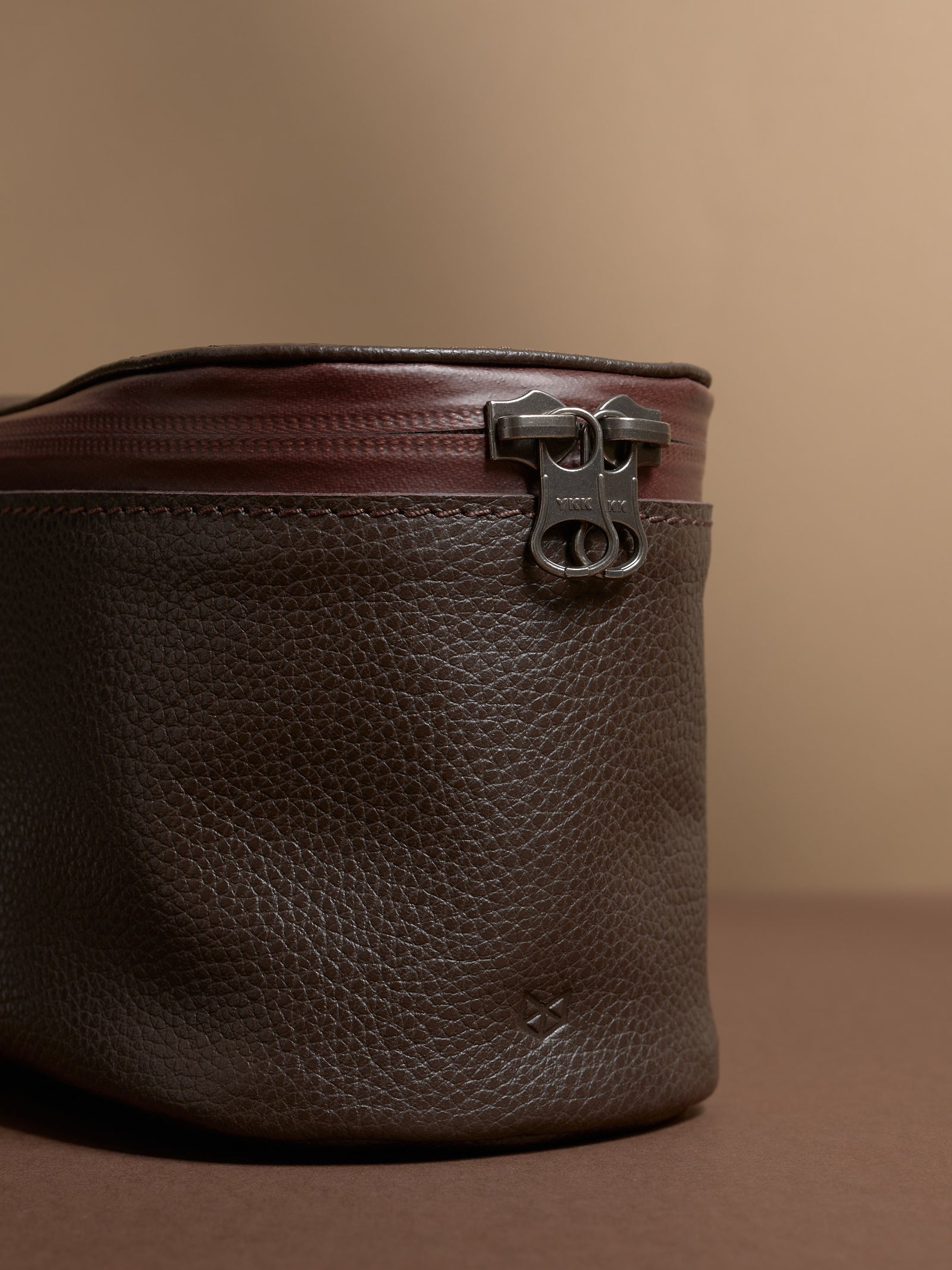 Close-up of the YKK zipper and the rich pebbled texture of the dark brown Capra Leather.