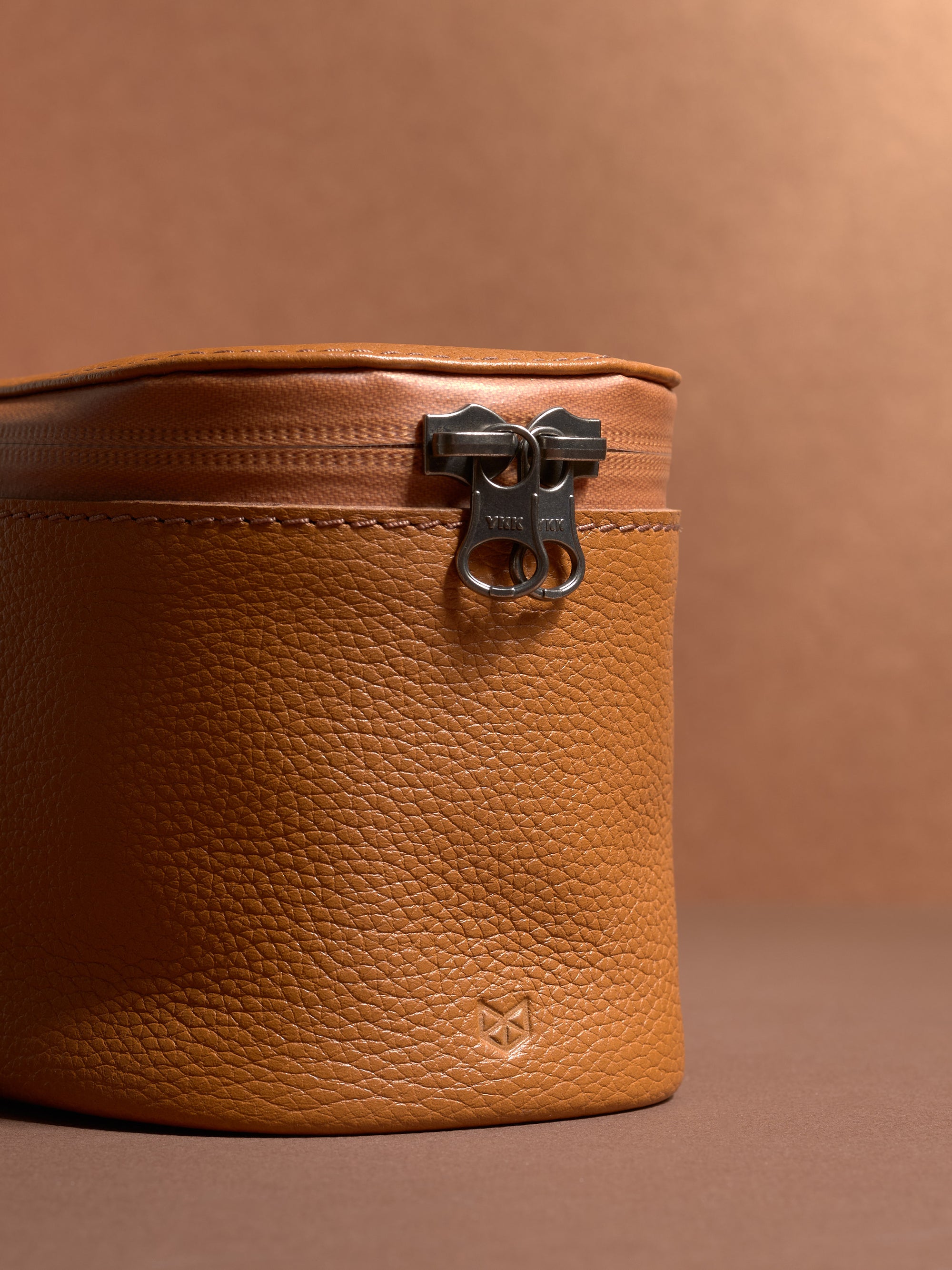 Close-up of the durable YKK zipper and pebbled tan Capra Leather texture.