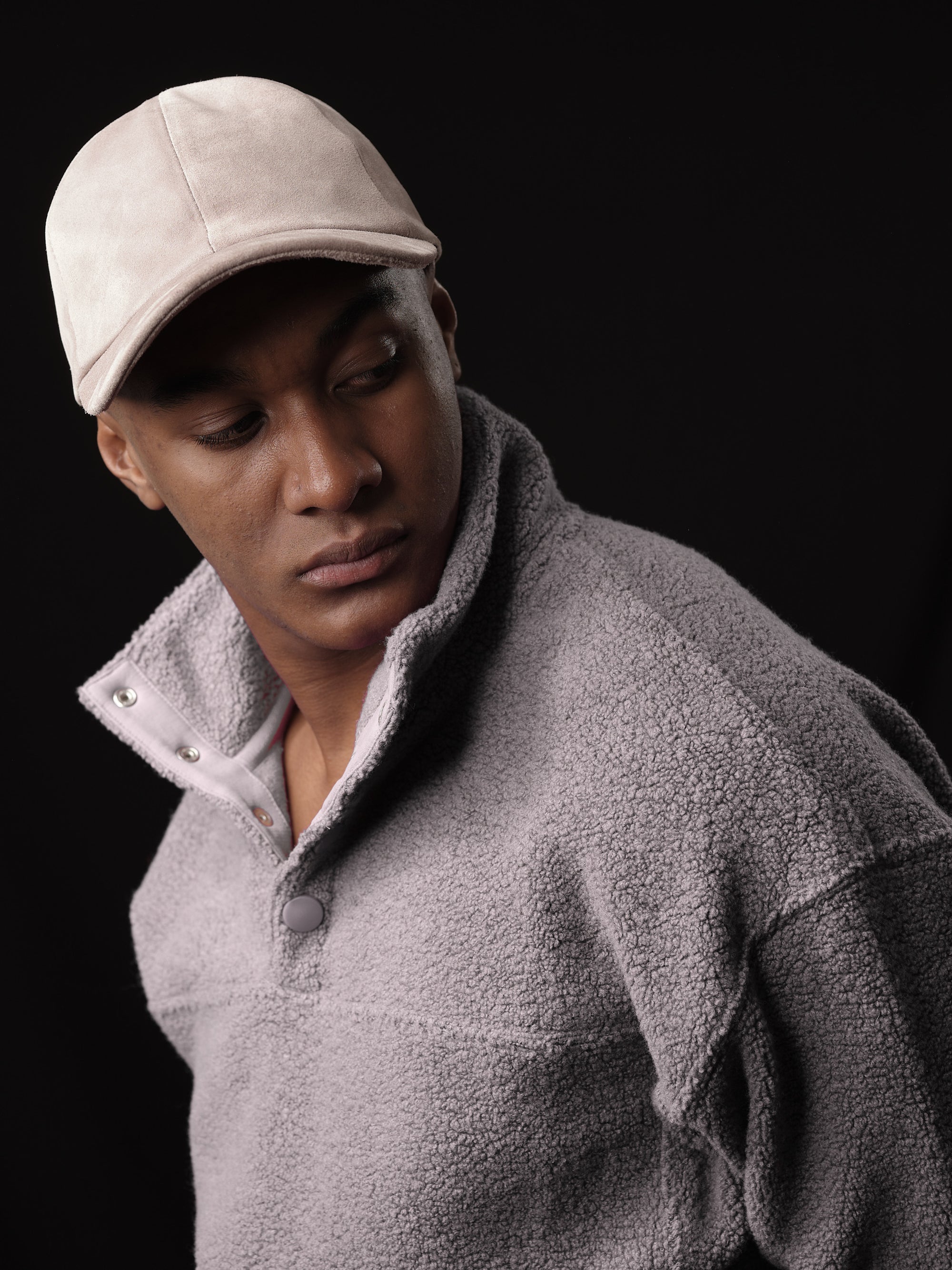 Studio shot of a man in a classic stone suede baseball cap with ear flaps 