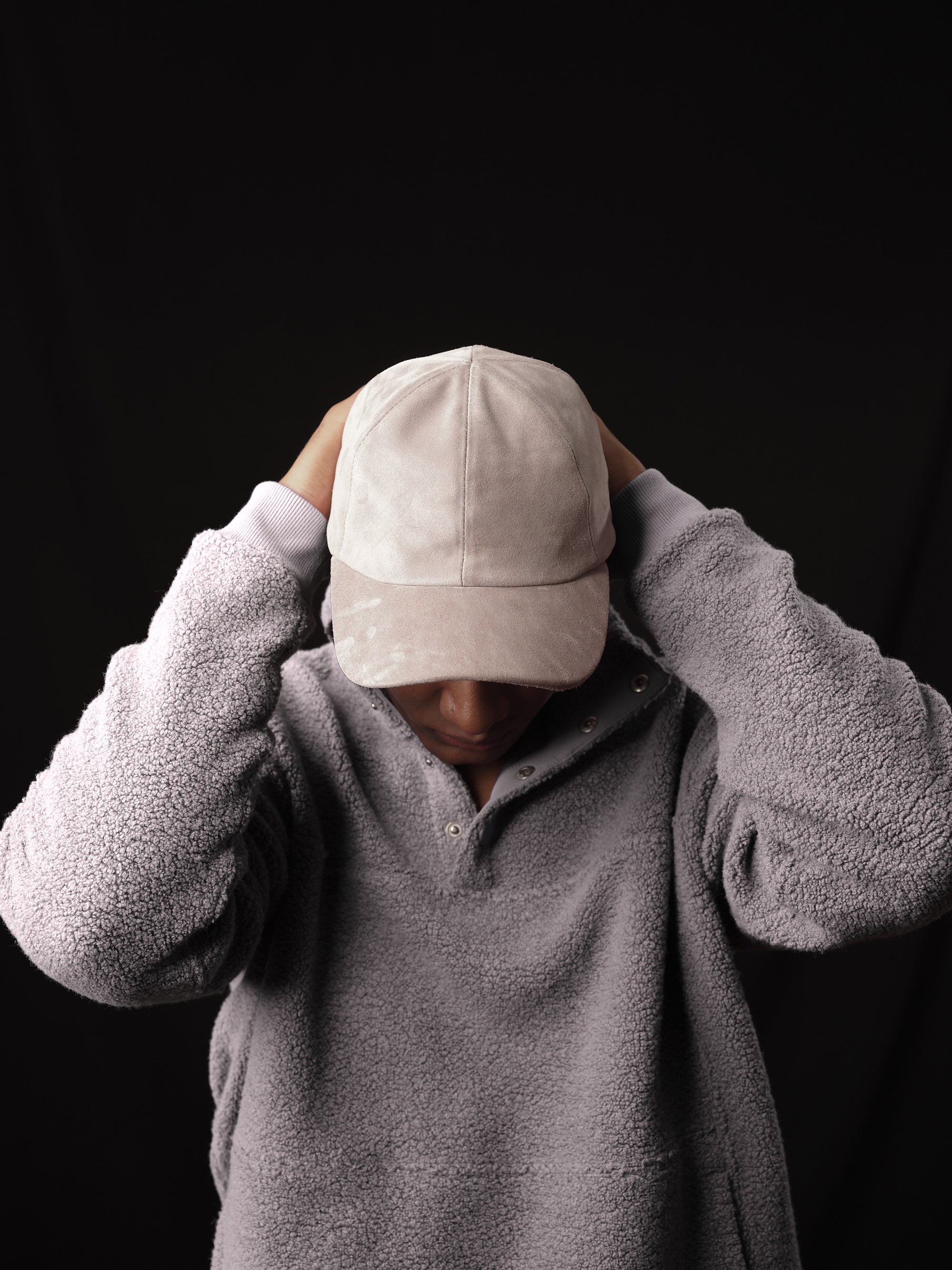 Detail of the braided strap and buckle on a stone suede baseball cap 