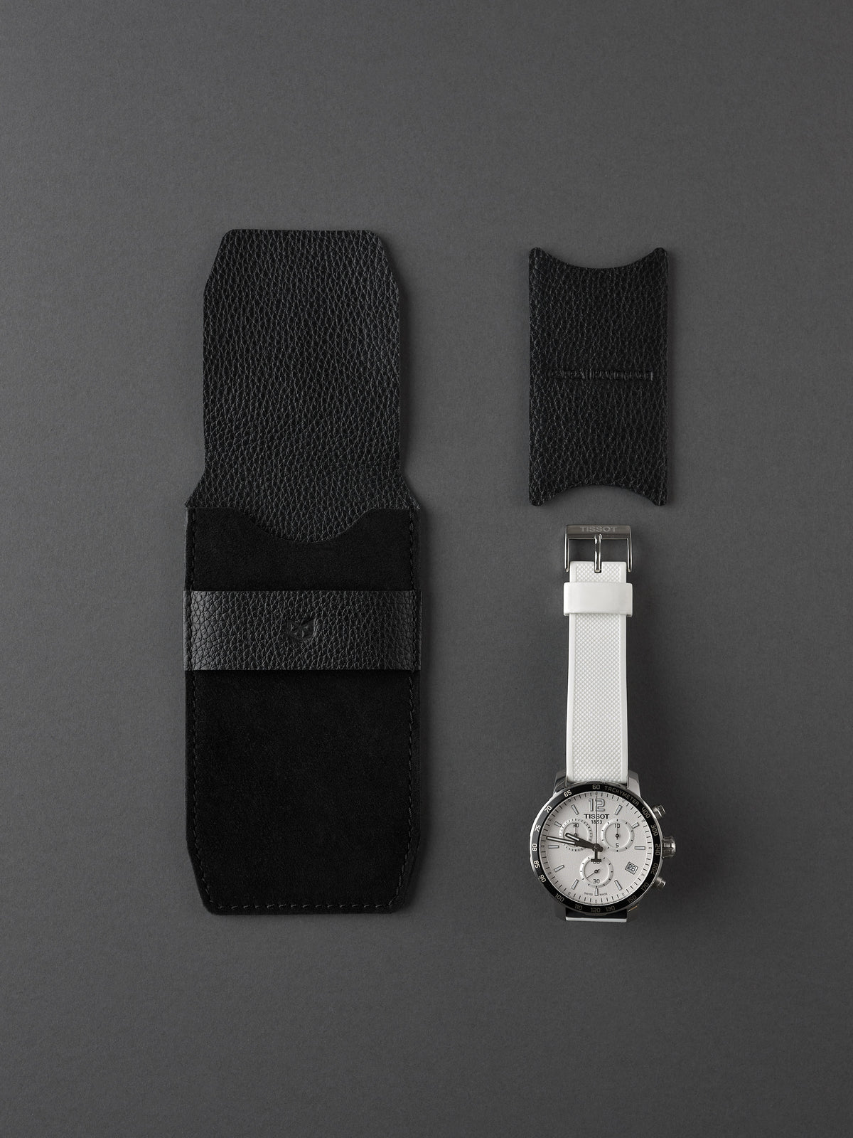 Capra Leather black suede watch pouch and small watch insert next to a men's white strap watch.