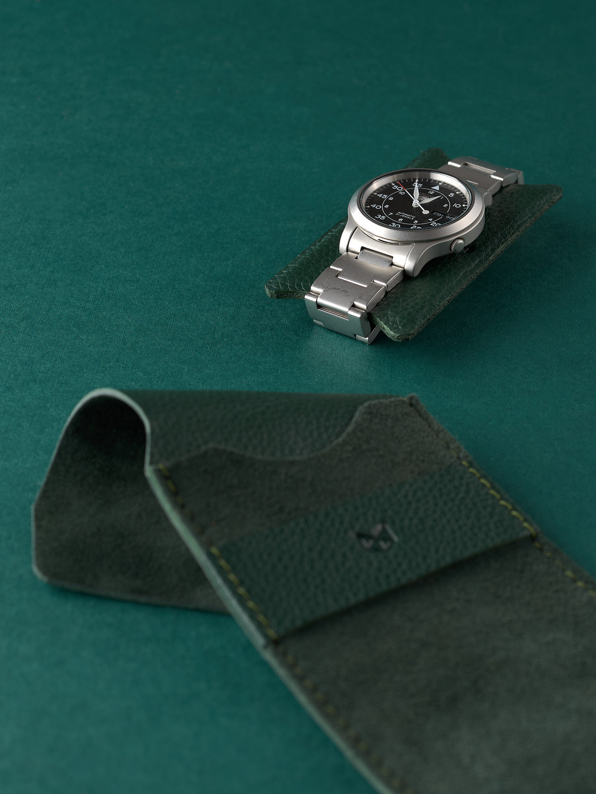 Men's automatic watch on a small green leather insert with a Capra Leather watch pouch. Watch conservation.