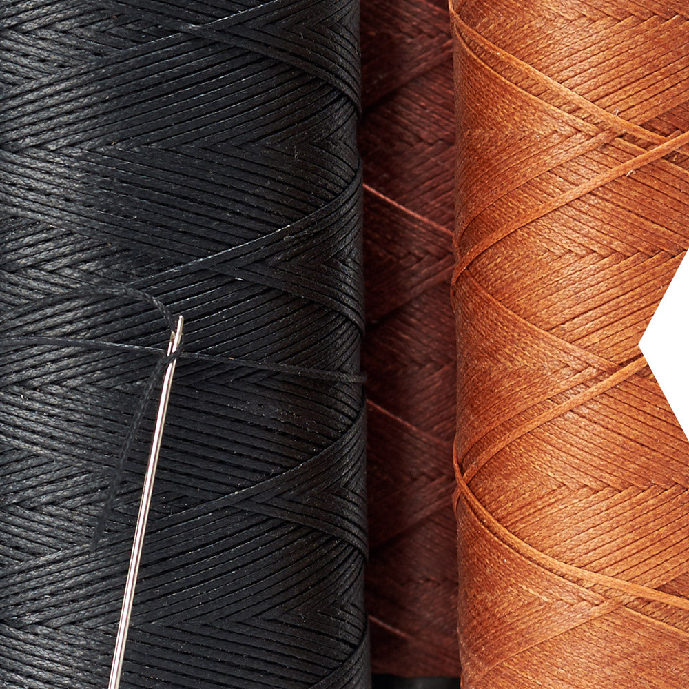 Black and tan waxed thread with a needle, for hand stitching leather