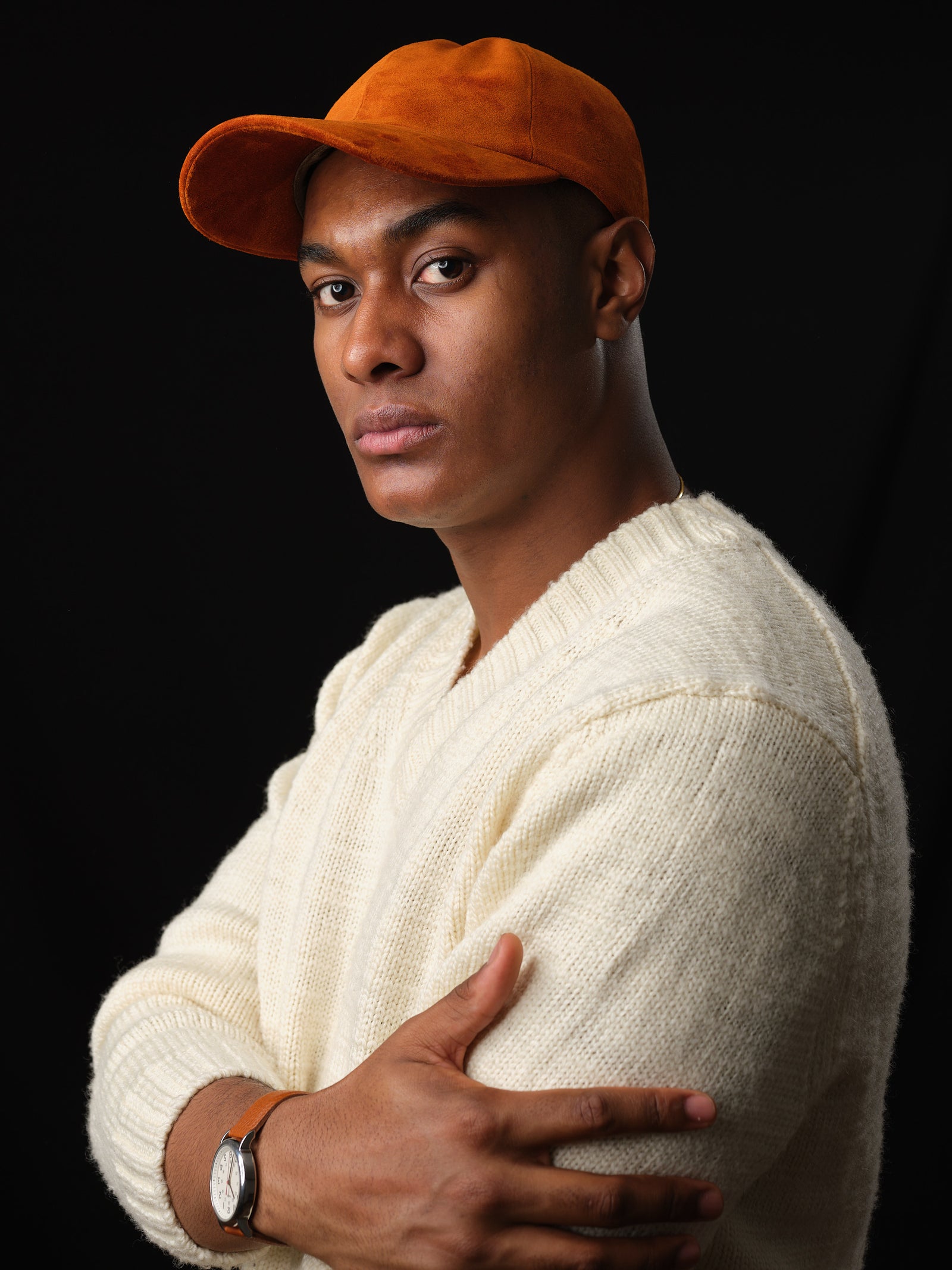 Studio shot of a man in a classic tan suede baseball cap with ear flaps 