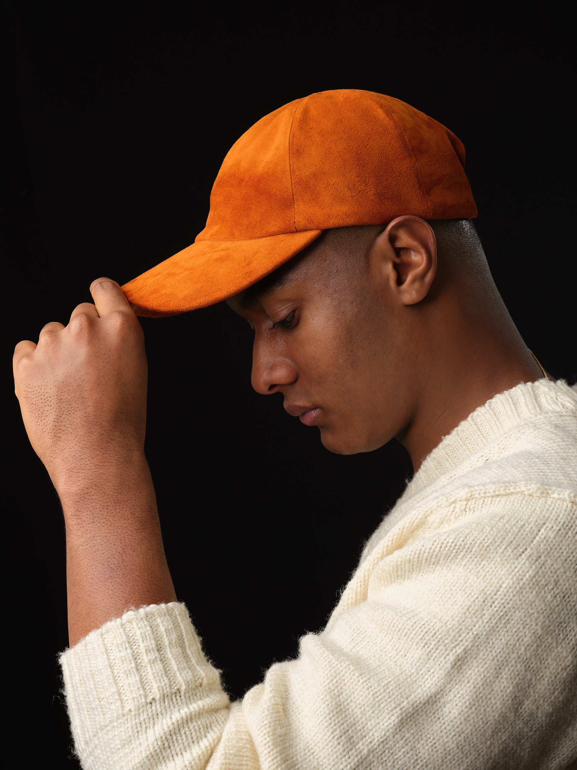 Studio shot of a man in a classic tan suede baseball cap with ear flaps 