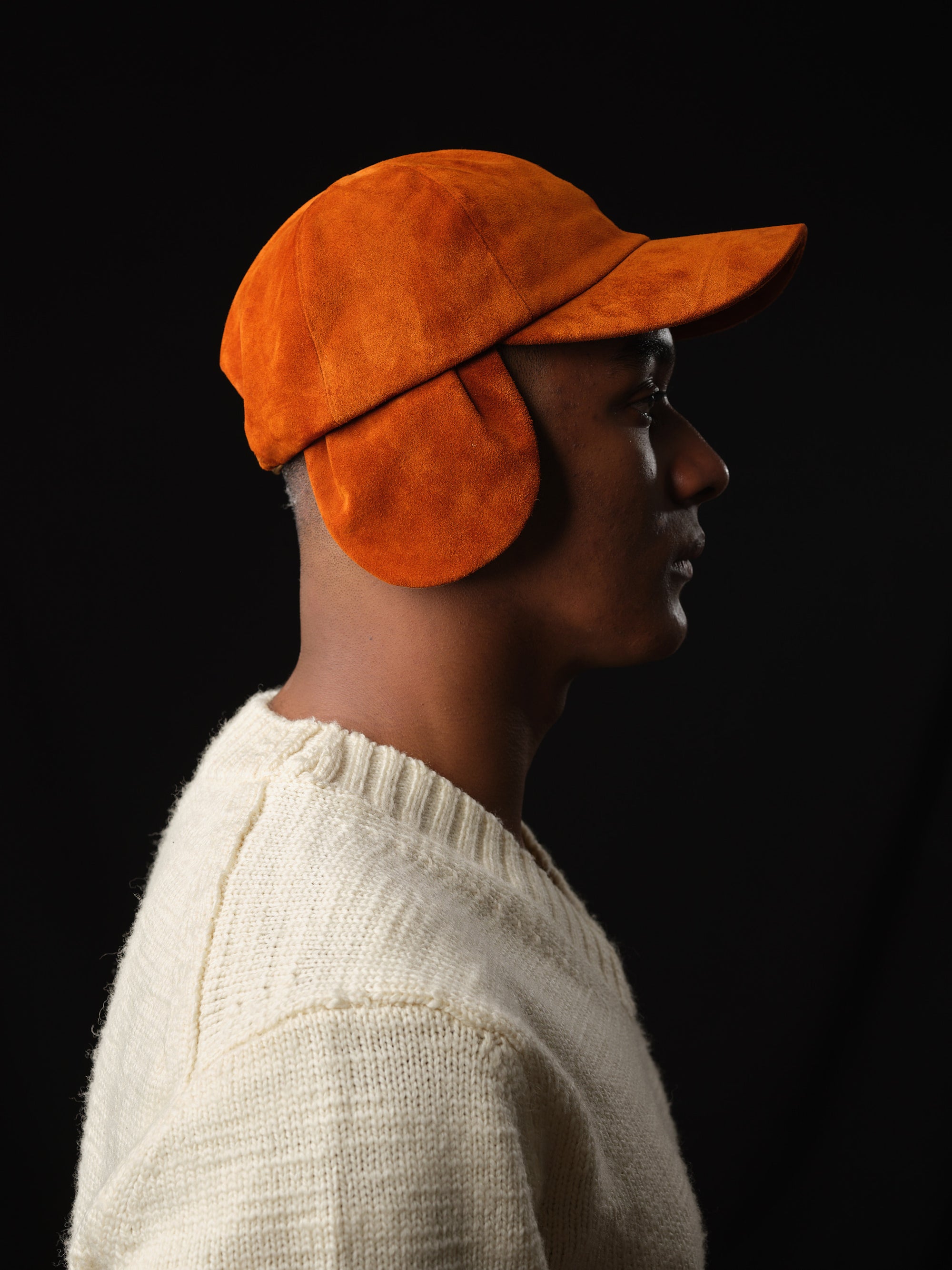 Athletic model wearing a tan suede baseball cap, handcrafted by Capra Leather