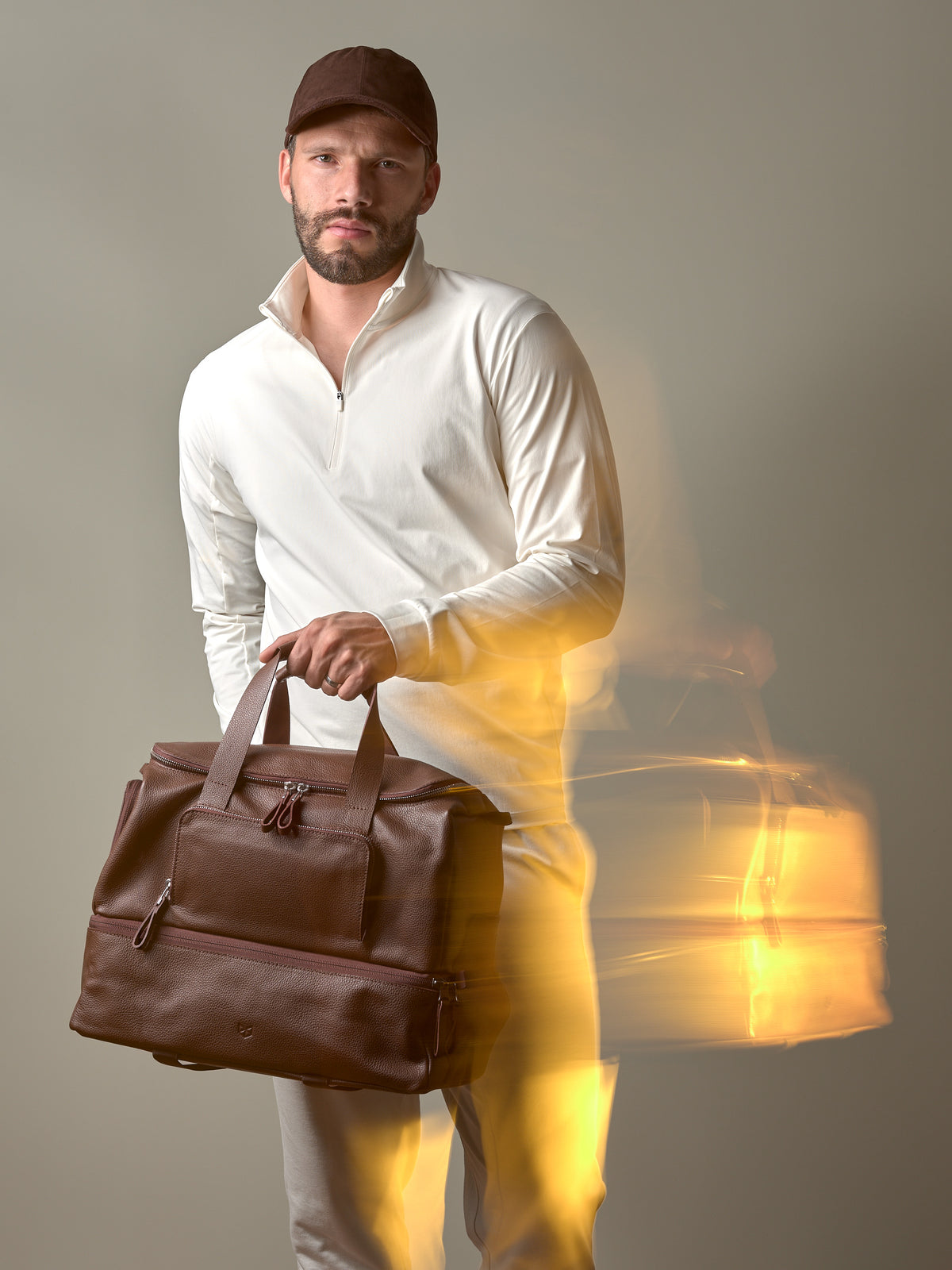 A creative motion-blur photo of a man holding the brown Ventra Holdall, conveying a sense of style and movement.