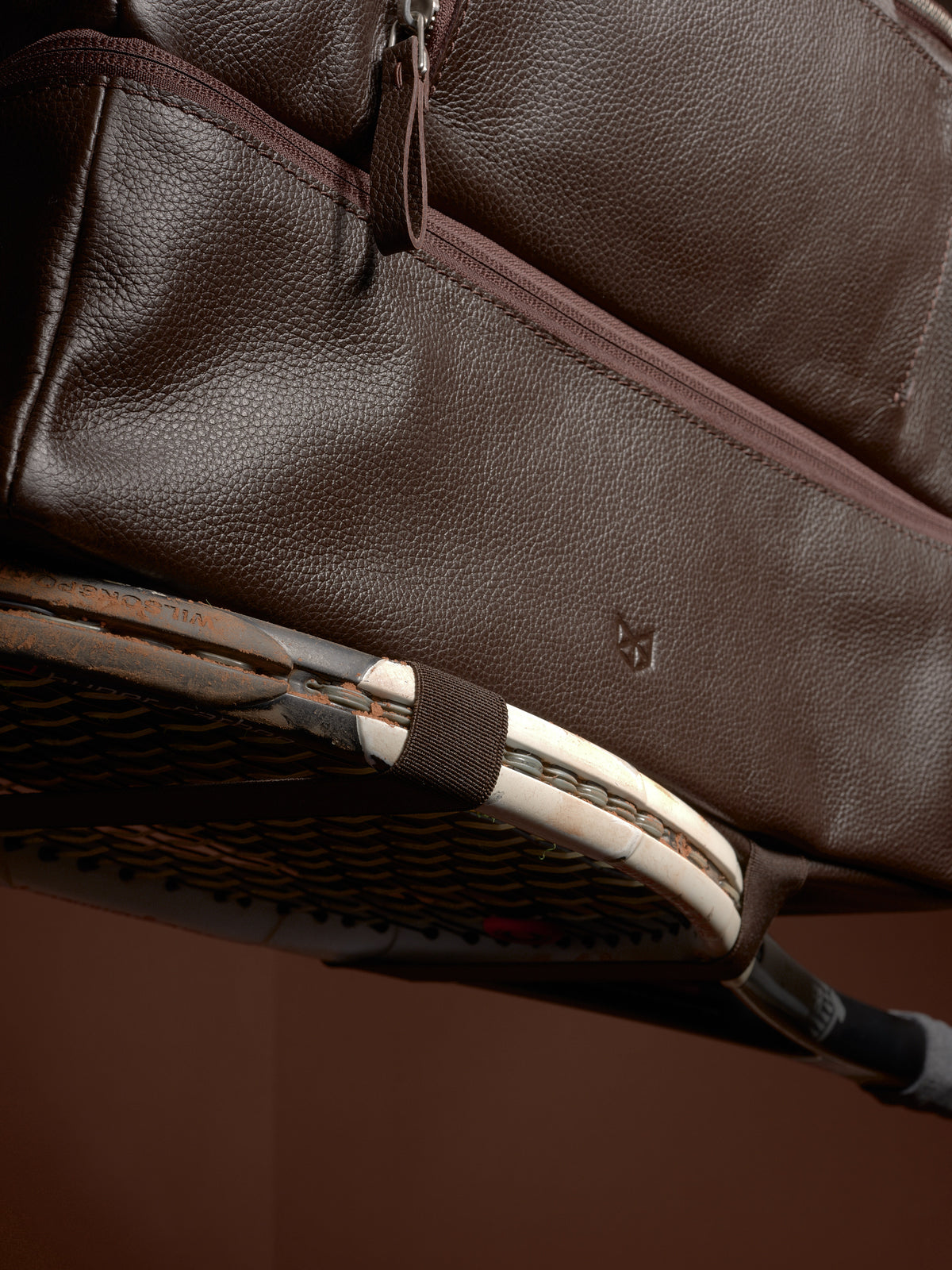 Close-up of the Ventra Holdall bag's side straps holding a tennis racket.