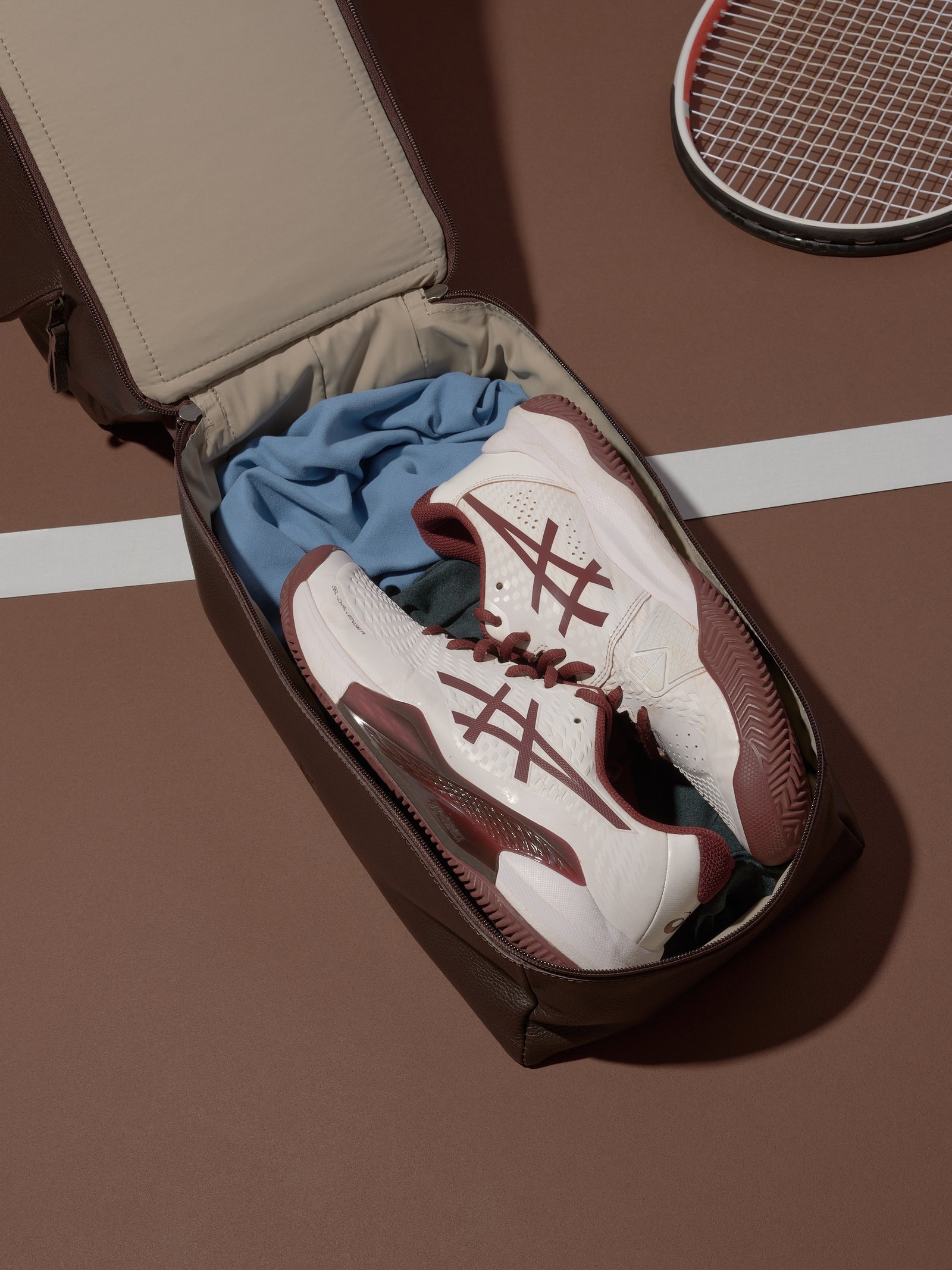 The Ventra Holdall bag with a lower compartment unzipped, revealing a pair of white tennis shoes.