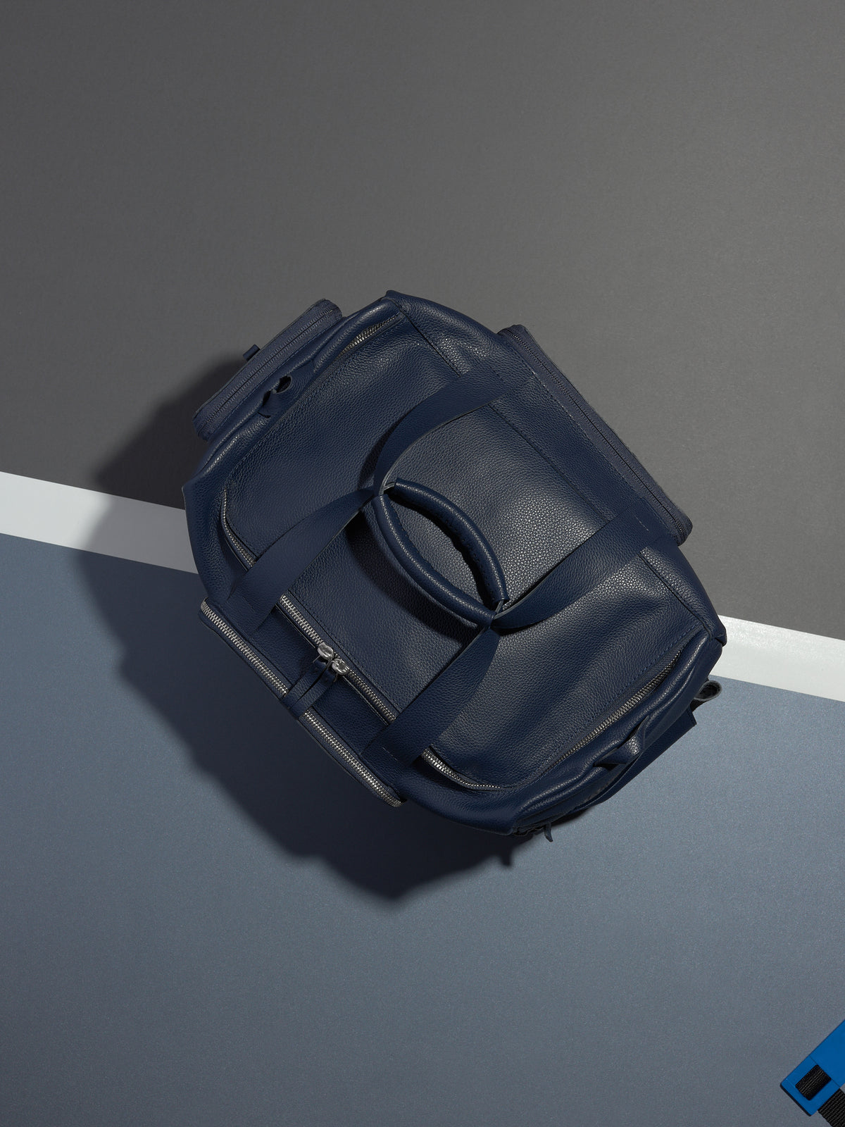 The Ventra Holdall duffle bag lying on a tennis court with a white line and blue background.