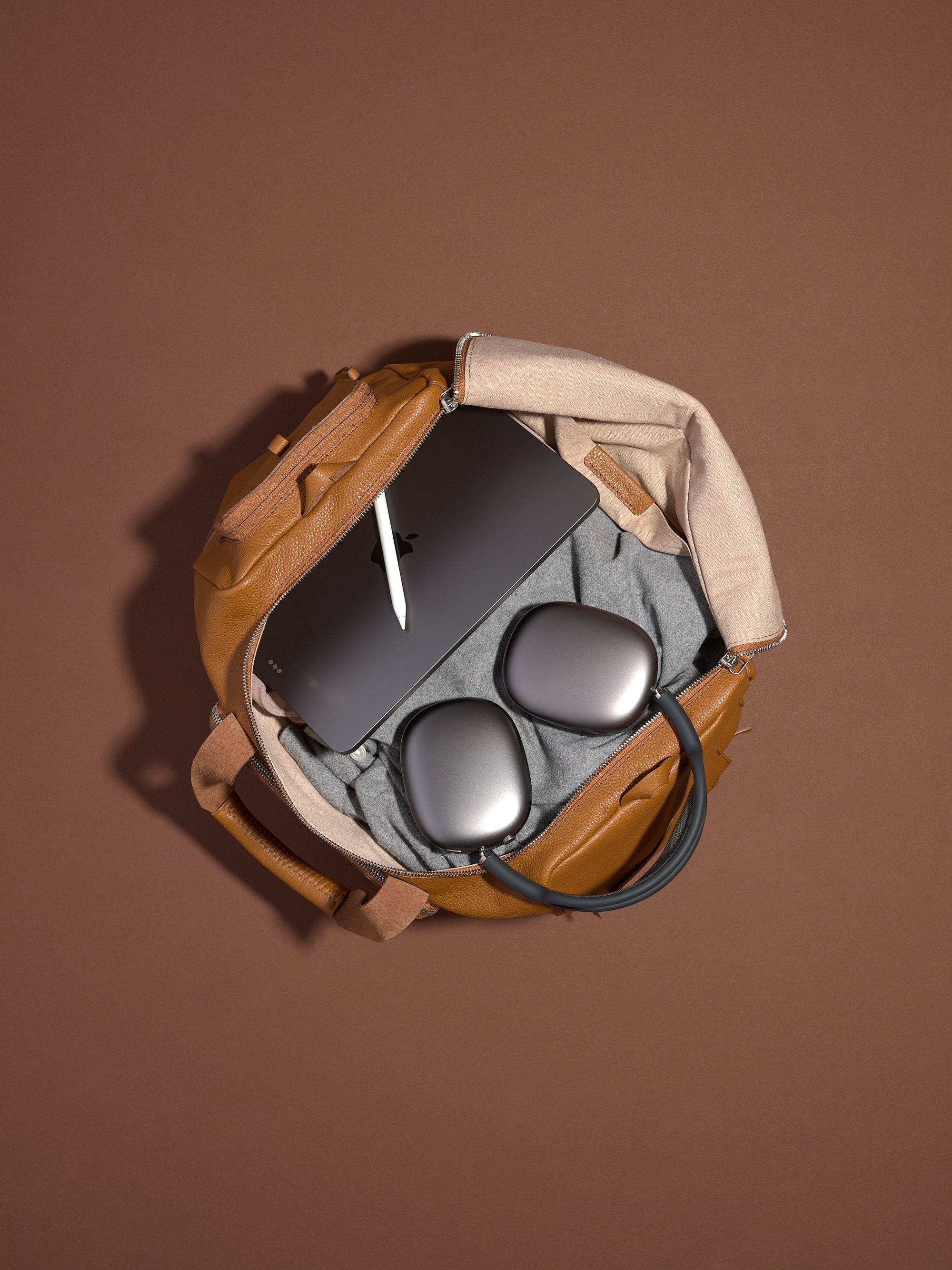 The tan leather Ventra Holdall weekender bag for men, shown with its shoulder strap, highlighting its classic duffel shape.