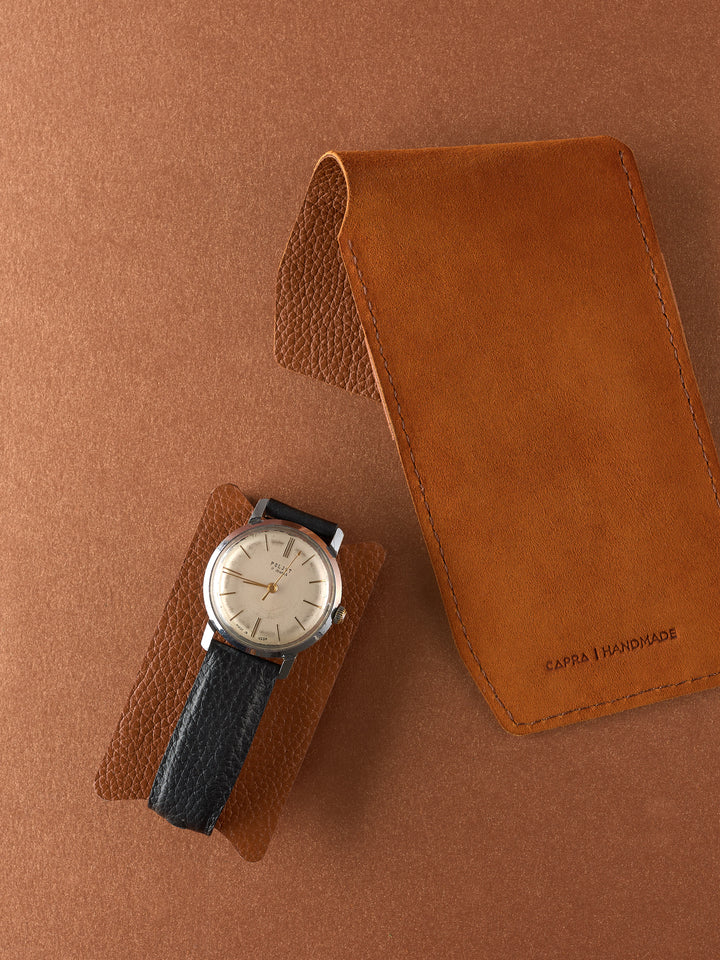 Capra Leather tan leather watch pouch and small watch insert next to a men's vintage dress watch.