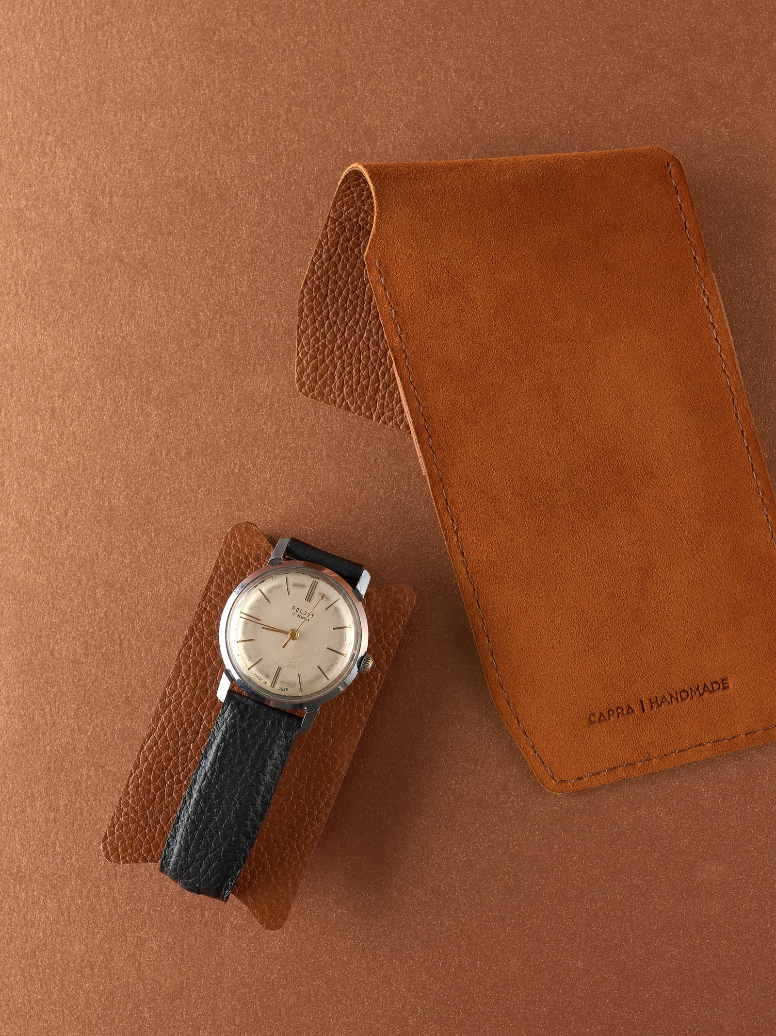 Capra Leather tan leather watch pouch and small watch insert next to a men's vintage dress watch.