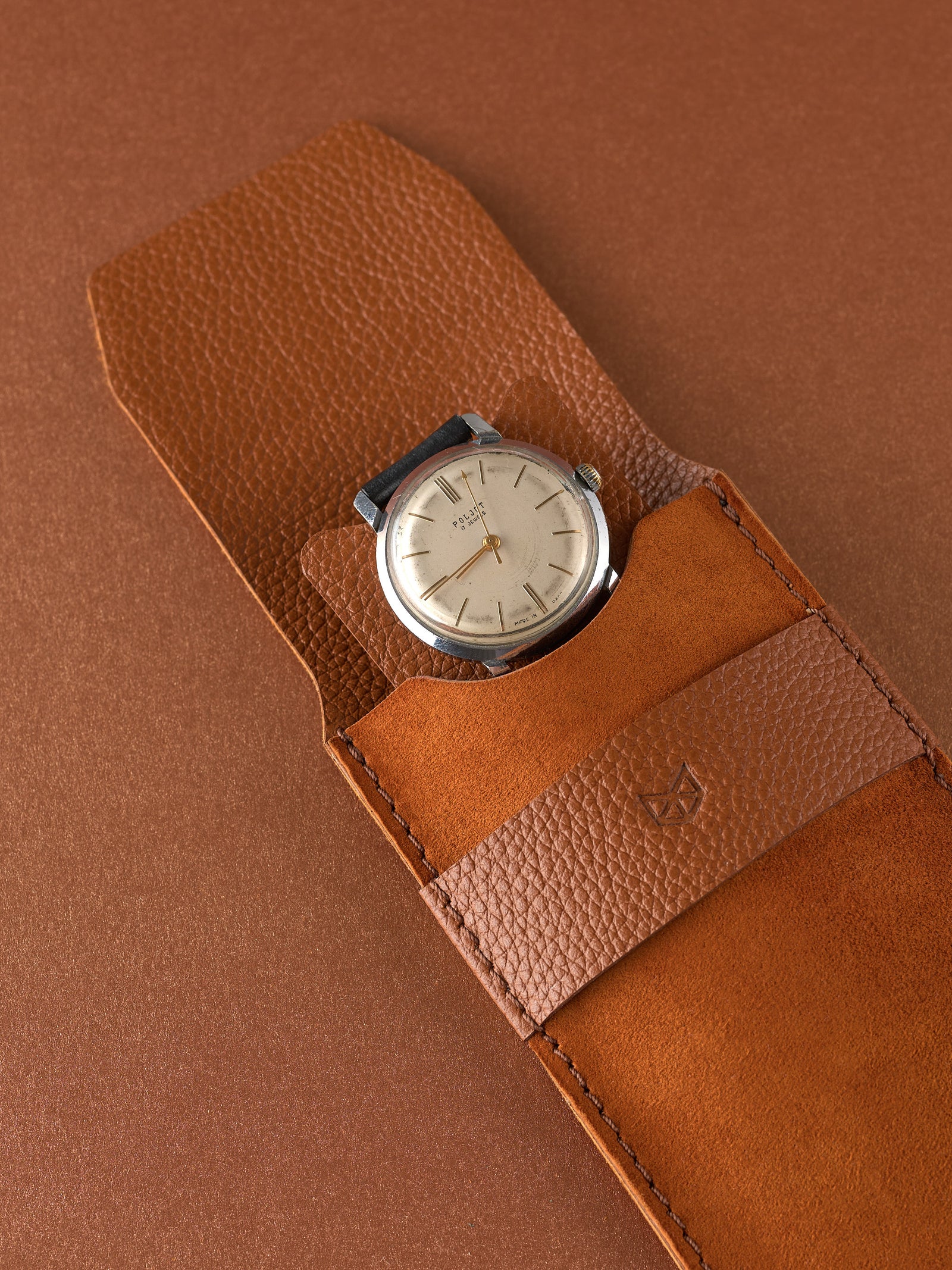 Capra Leather tan leather watch pouch and small watch insert next to a men's vintage dress watch.